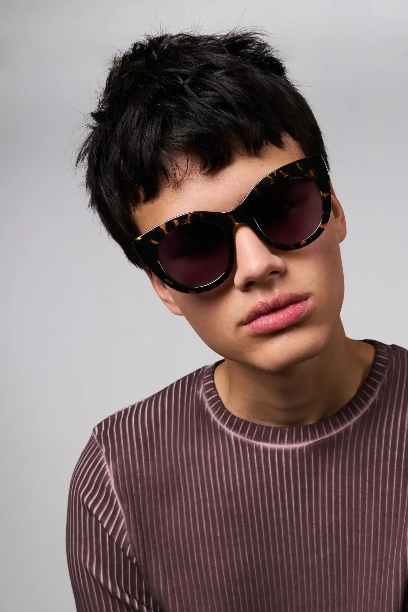 Louise Dark Tortoise Sunglasses worn by a model, featuring a cat eye design for UV protection and eco-friendly materials.