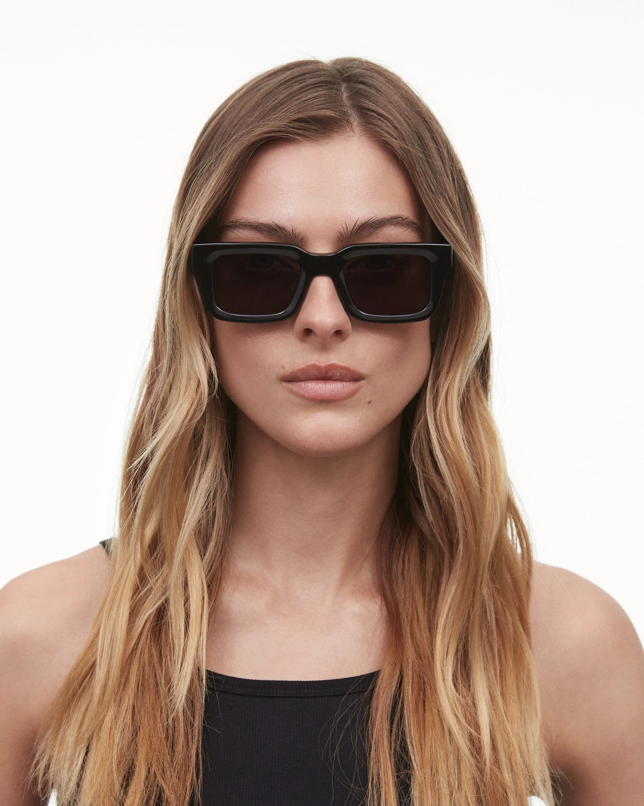 05 Core Black Sunglasses worn by a model with wavy hair, showcasing a stylish and modern design.