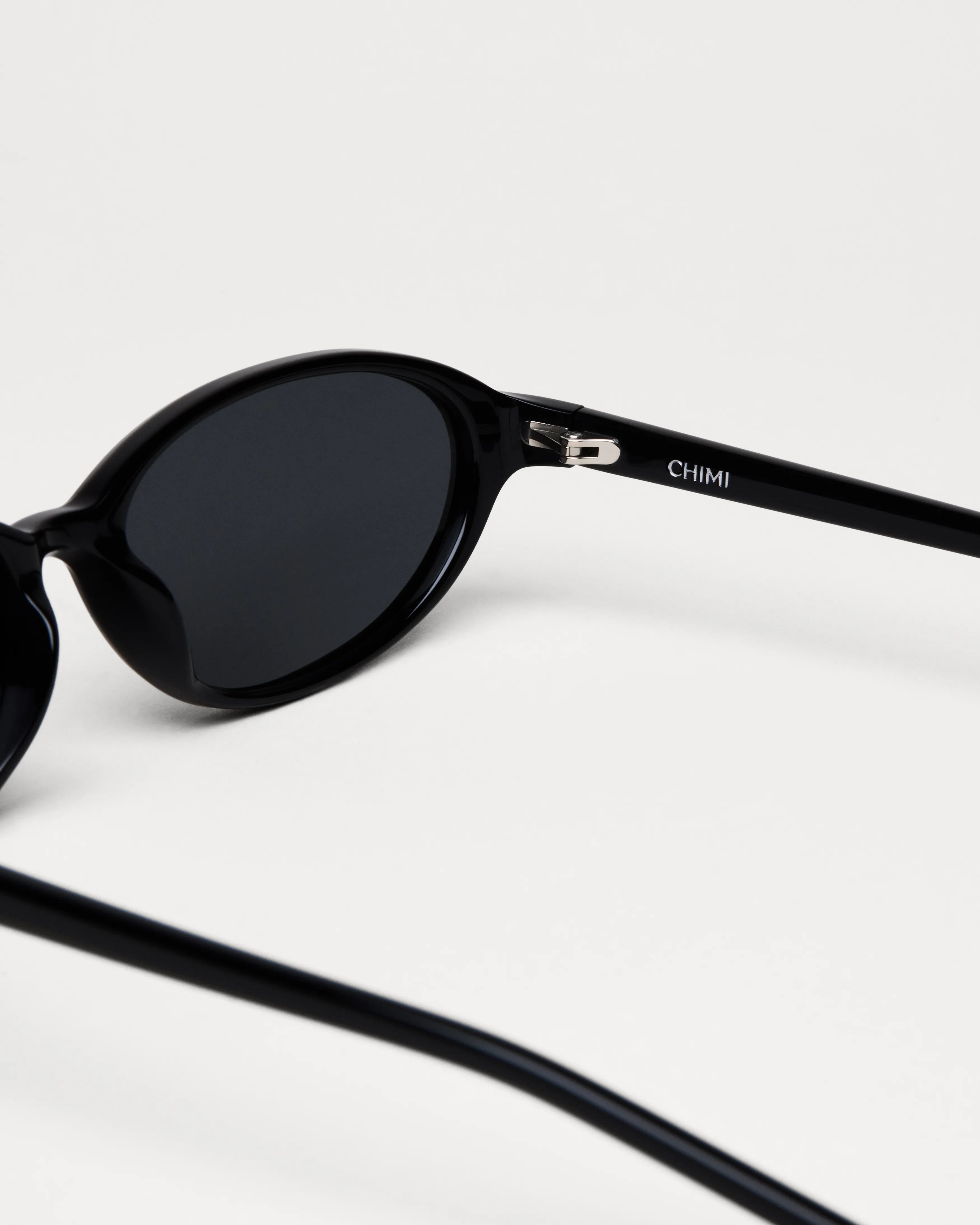 Ellipse Black Sunglasses with sleek design and anti-scratch lenses, featuring Chimi branding and durable Acetate material.