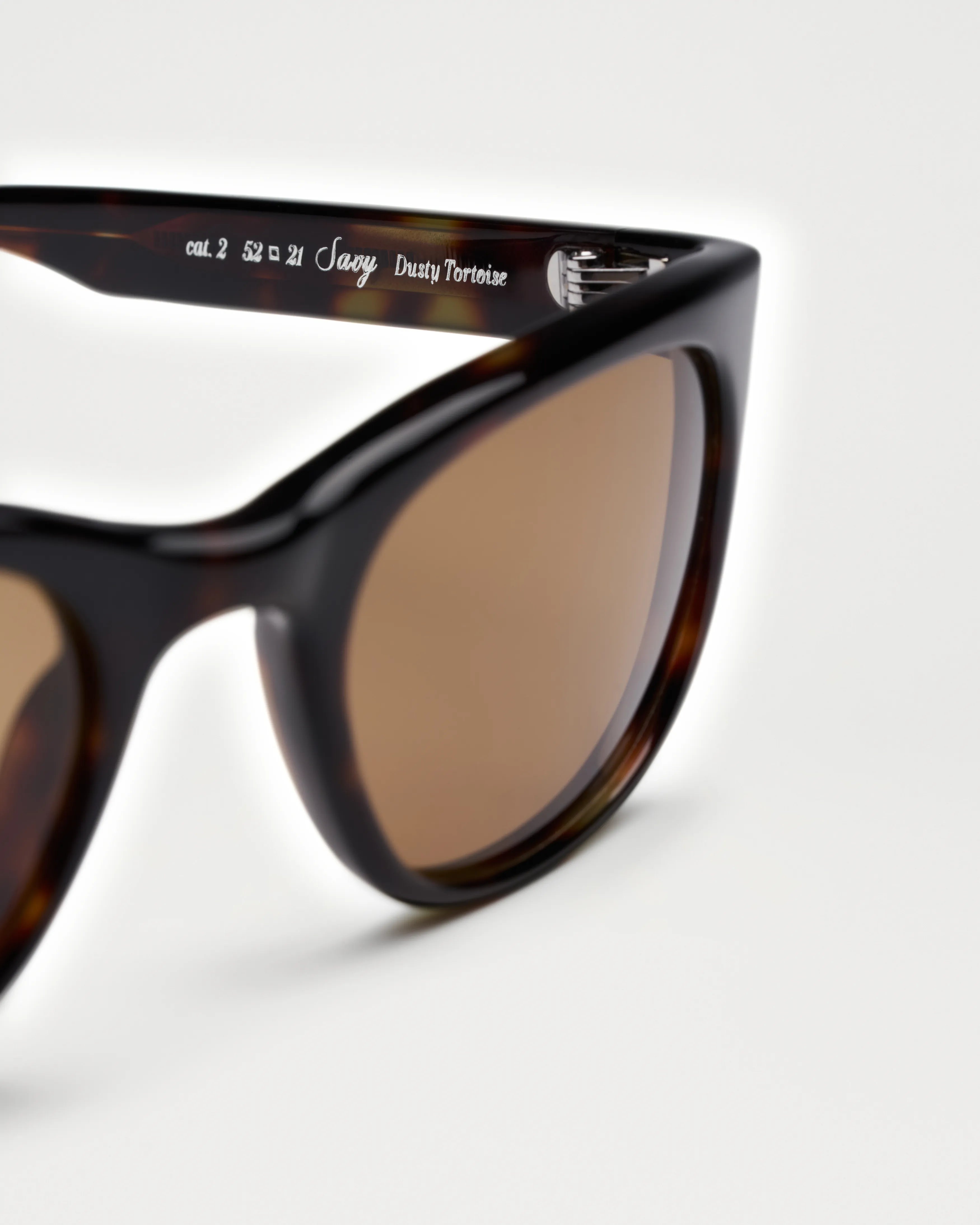 Savy Tortoise Sunglasses showcasing durable Acetate Renew™ with brown anti-scratch lenses and stylish design.