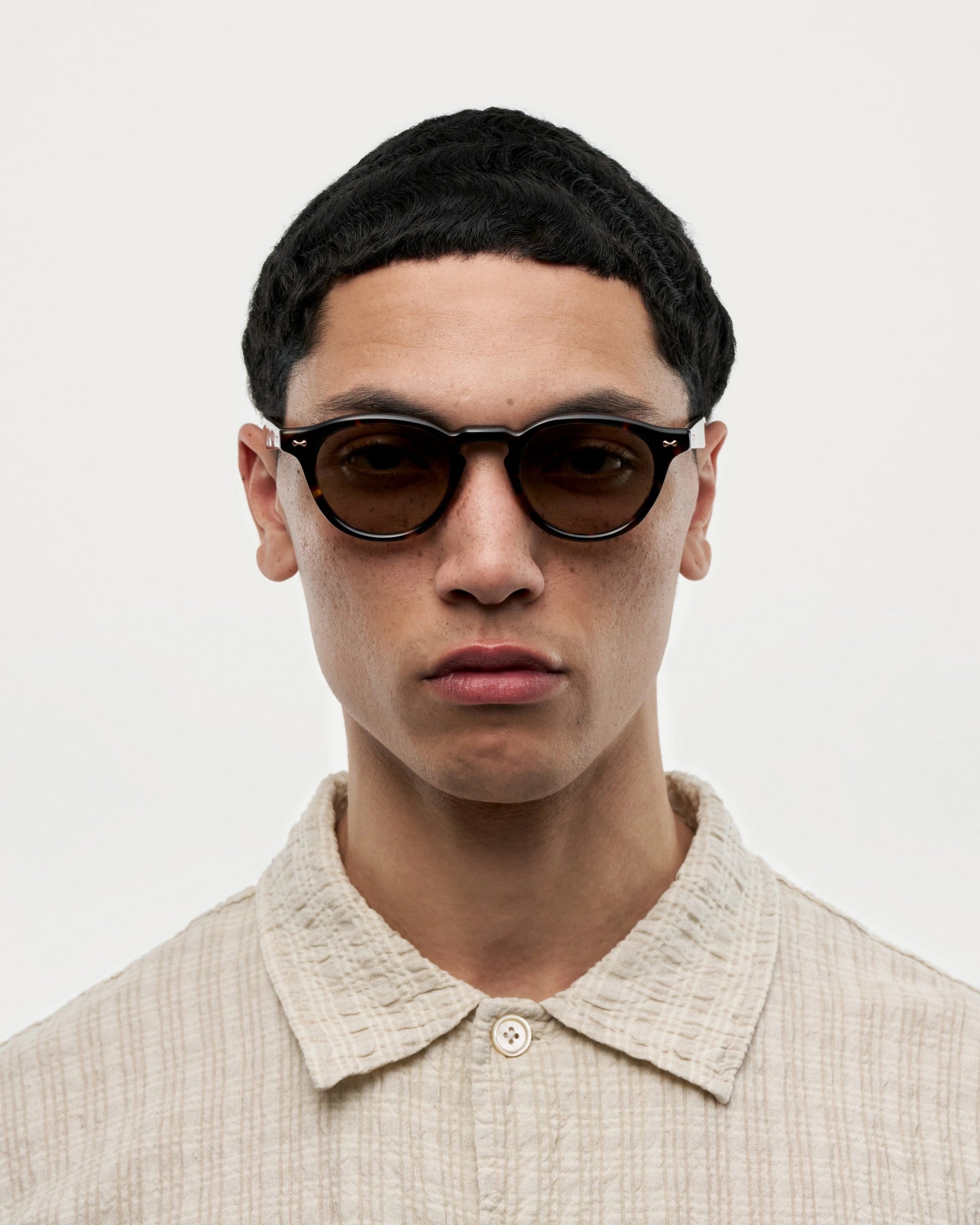 A model wearing Scope Tortoise Sunglasses, showcasing the stylish design and durable Acetate material.