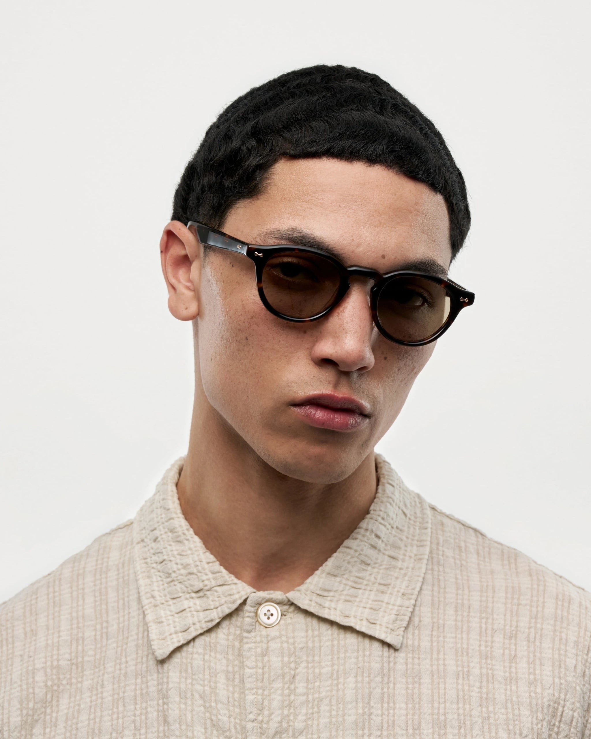 Man wearing Scope Tortoise Sunglasses, showcasing style and UV protection in a limited collection.
