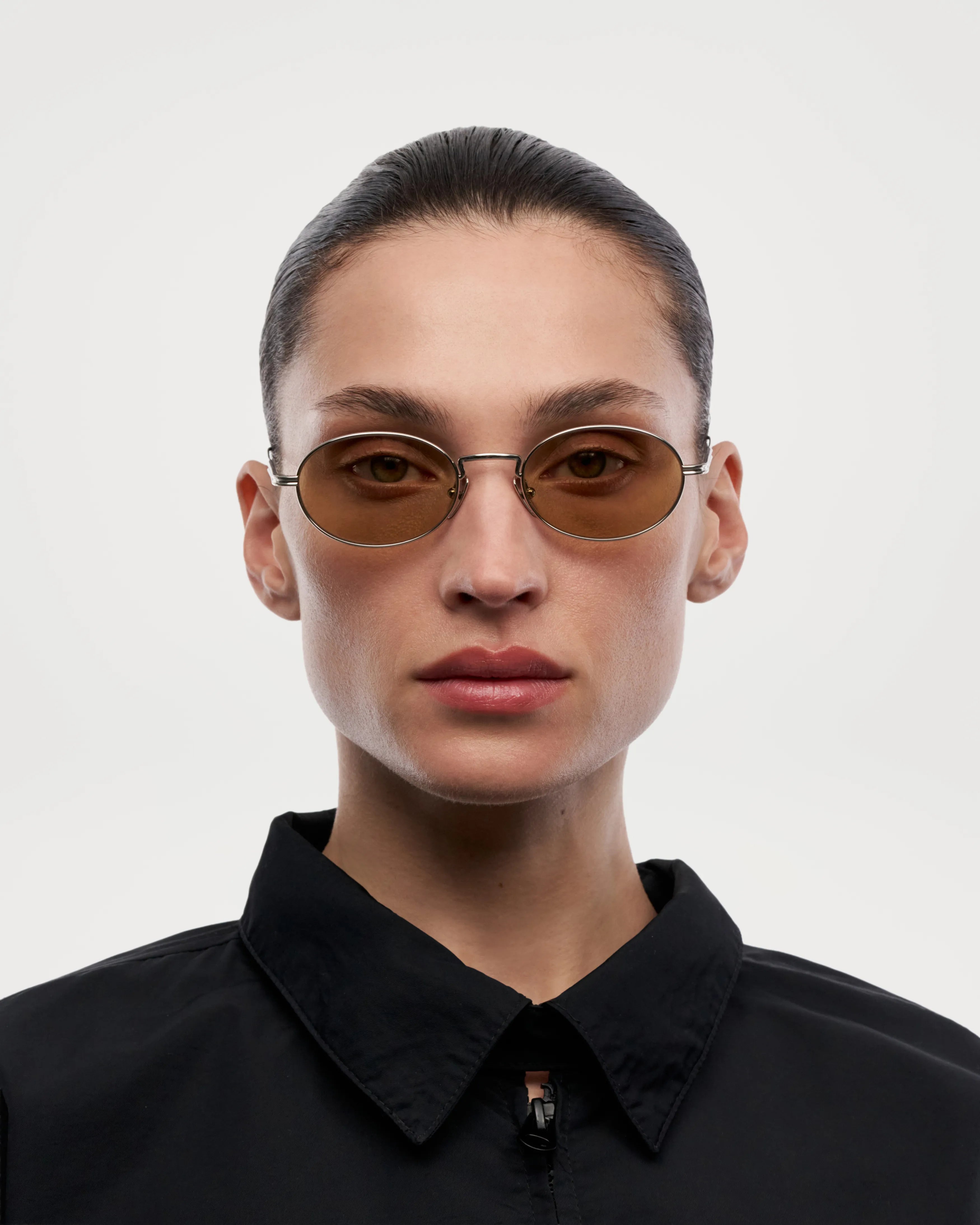 Oval Silver Sunglasses worn by a model, showcasing a modern design and UV 400 protection, ideal for unisex use.