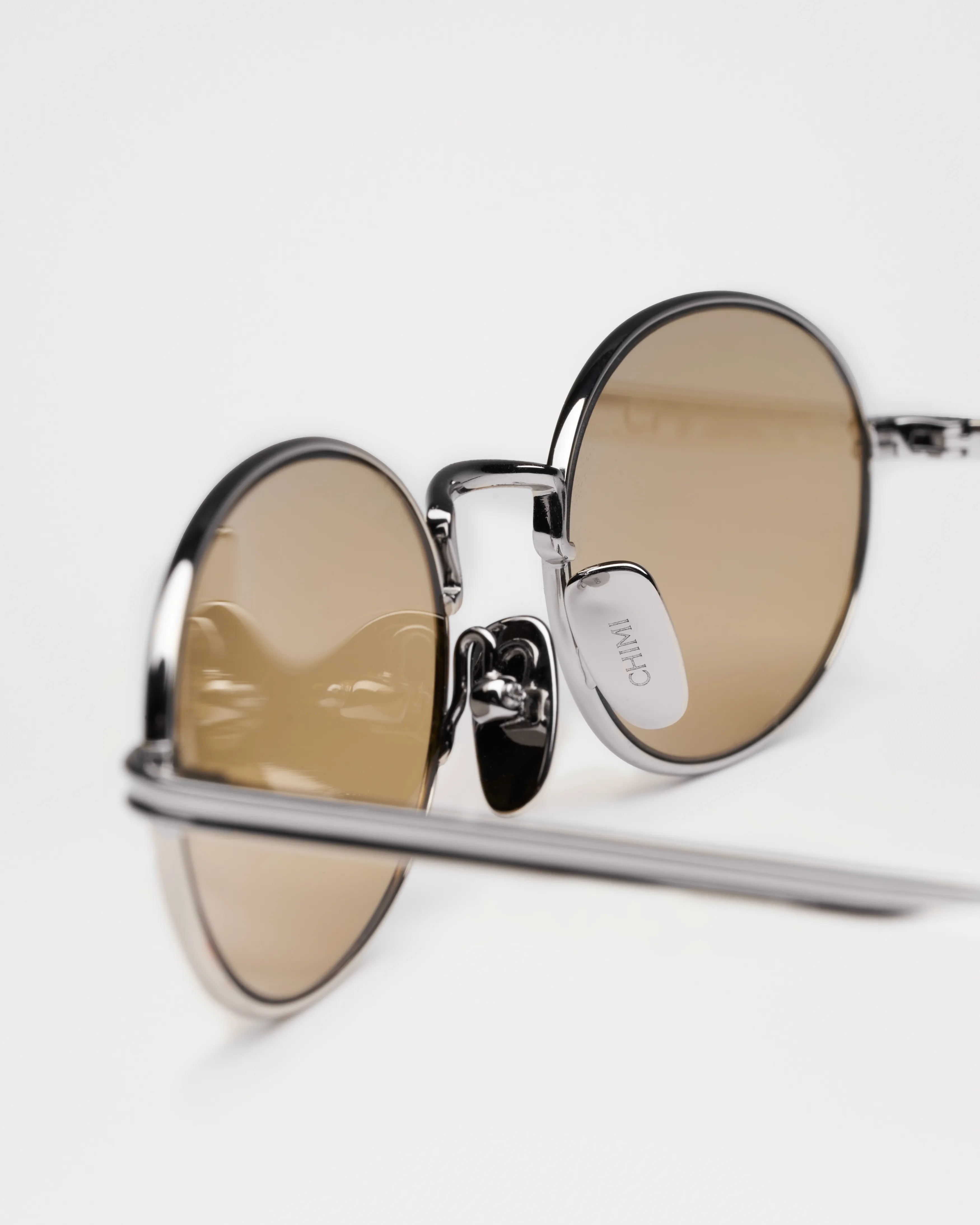 Oval Silver Sunglasses with brown lenses, showcasing a stylish unisex design and UV protection.