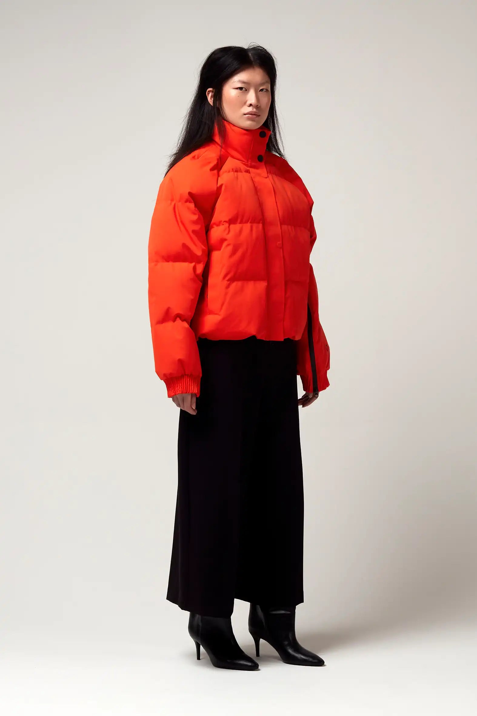 Model wearing Agasga Poppin Red Coat, showcasing its vibrant color and stylish design.