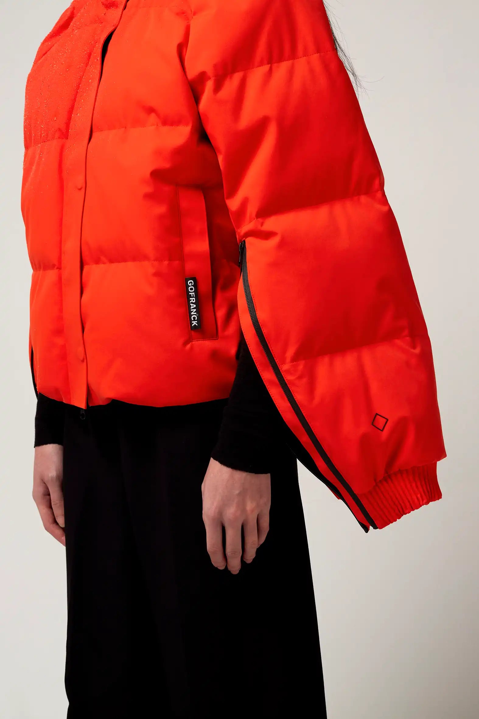 Agasga Poppin Red Coat showcased on model, highlighting sleeve zippers and vibrant red color.