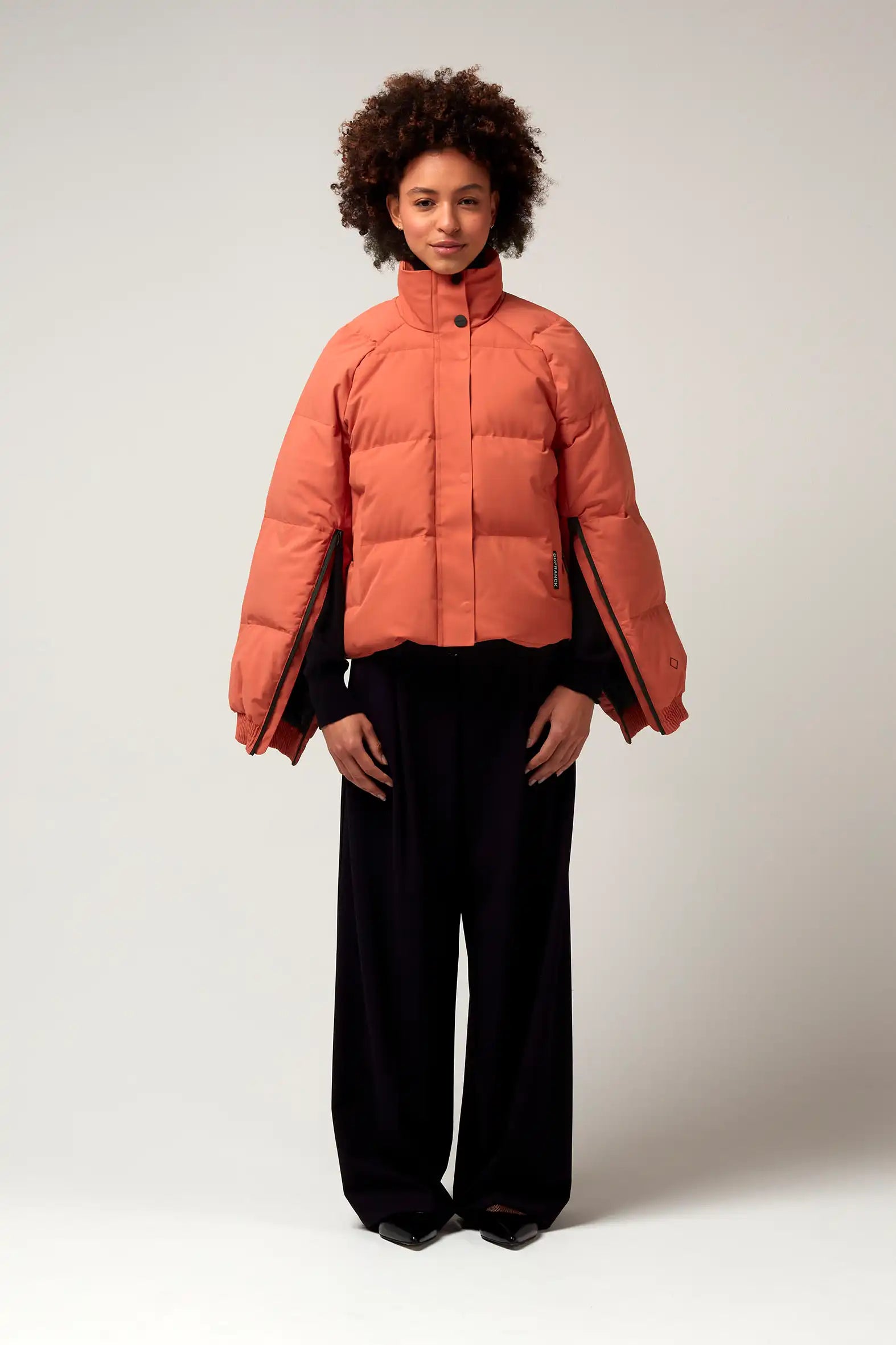Model wearing Agasga Apricot Coat, a lightweight, waterproof and windproof jacket with unique sleeve zippers.