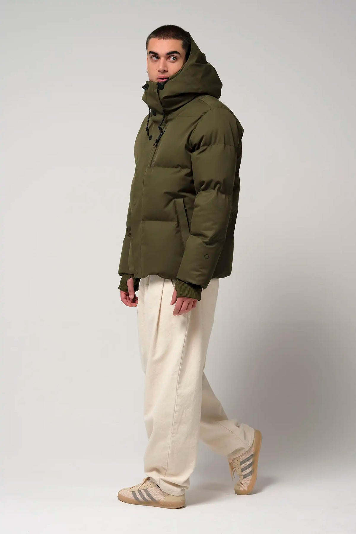 Bayu Dark Olive Green Coat worn by a model, showcasing waterproof, breathable, and windproof features.