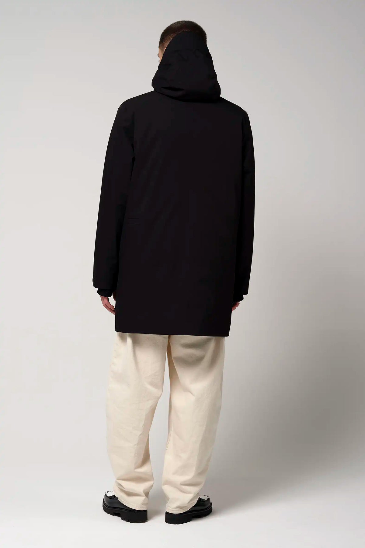 Model wearing the Cielo Deep Black Coat from the back, showcasing its waterproof and windproof features.