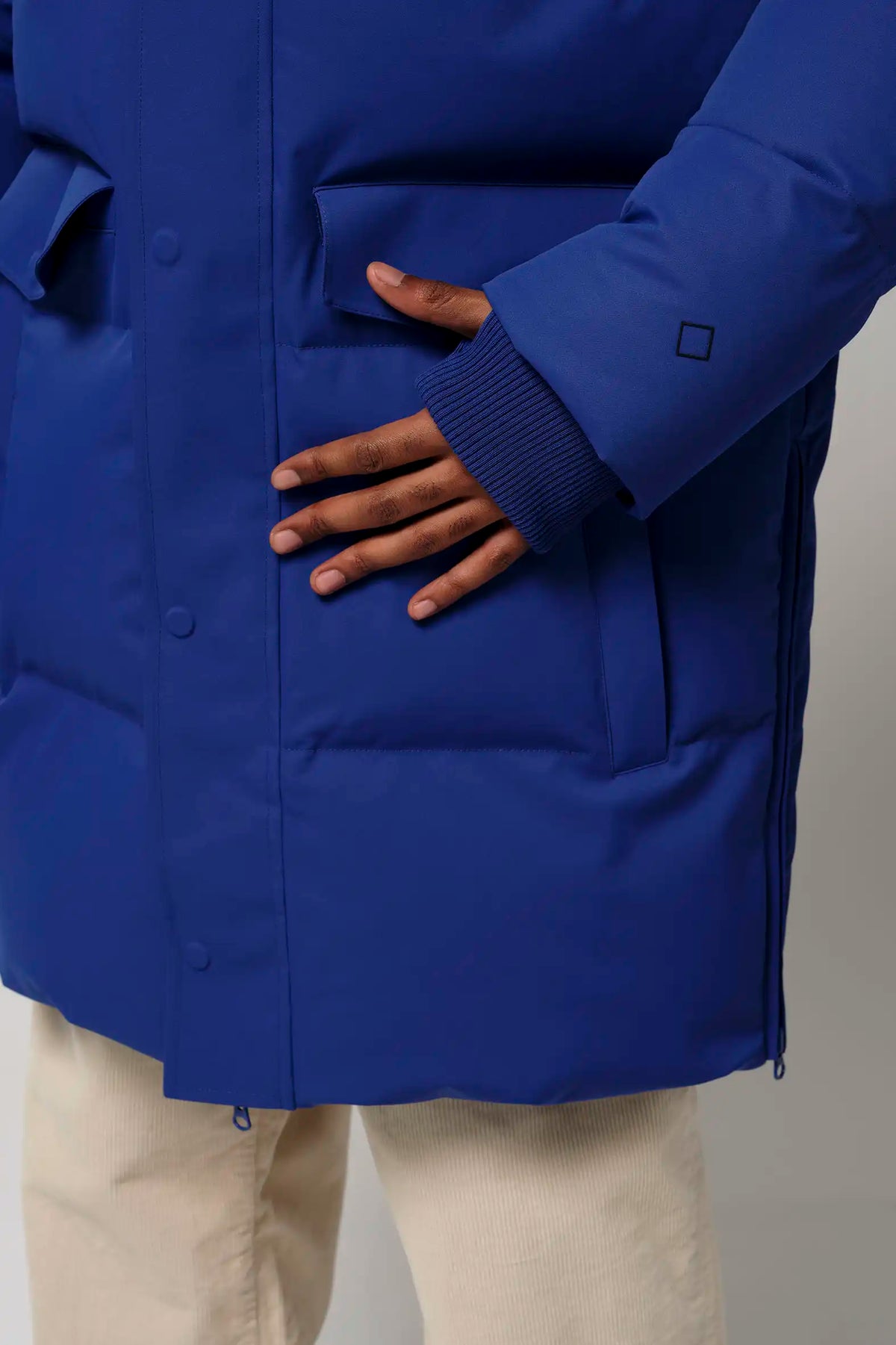 Close-up of hands on the side pockets of the Climate Sodalite Blue Coat, showcasing its stylish design.