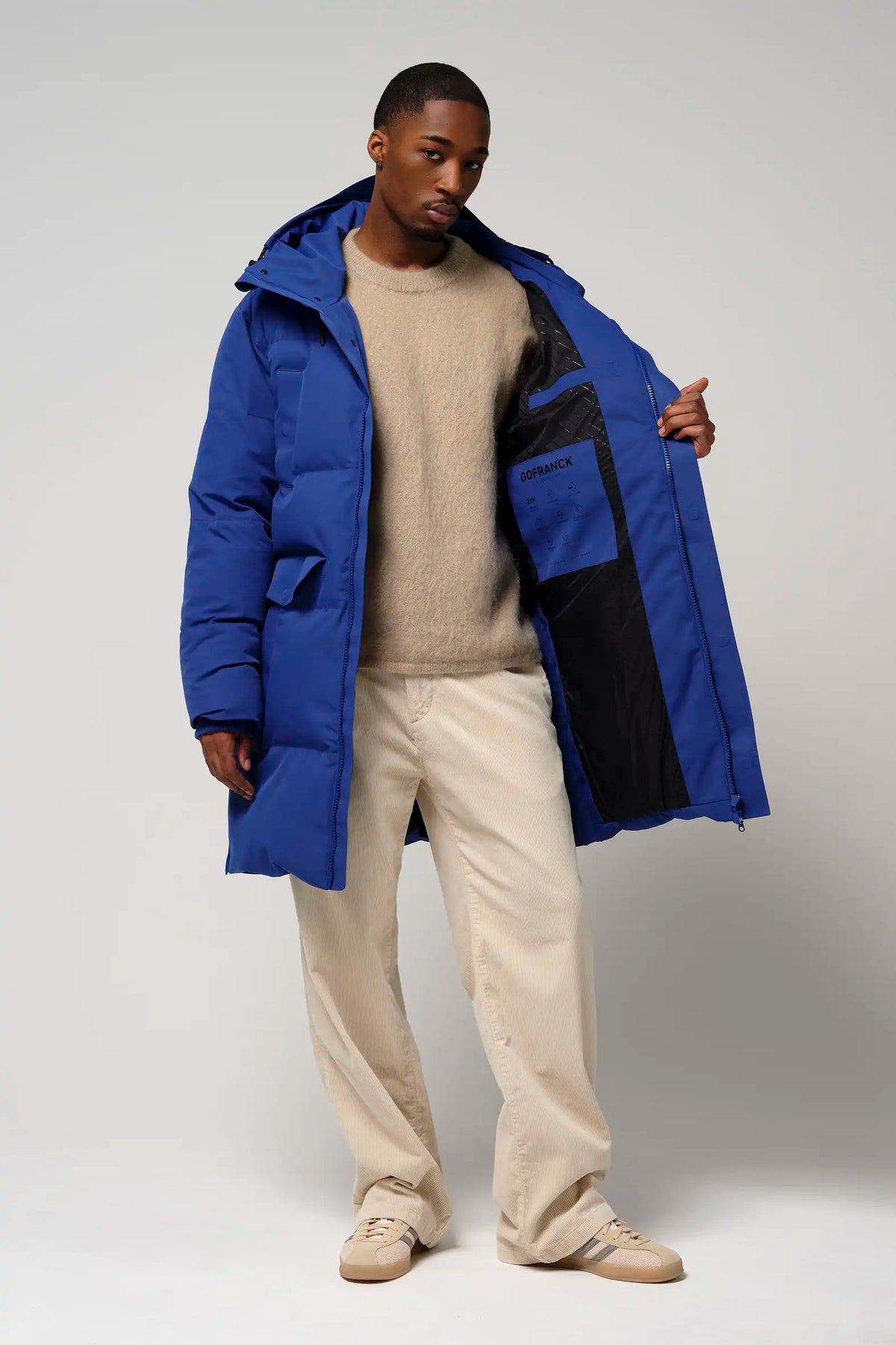 Model wearing the Climate Sodalite Blue Coat, showcasing its features and design elements in an indoor setting.