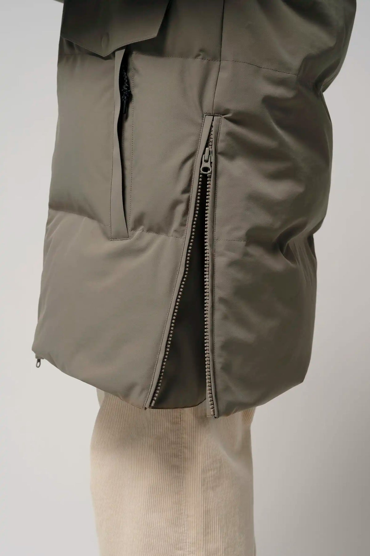 Climate Timber Wolf Grey Coat side zipper detail showcasing its waterproof design and modern style.