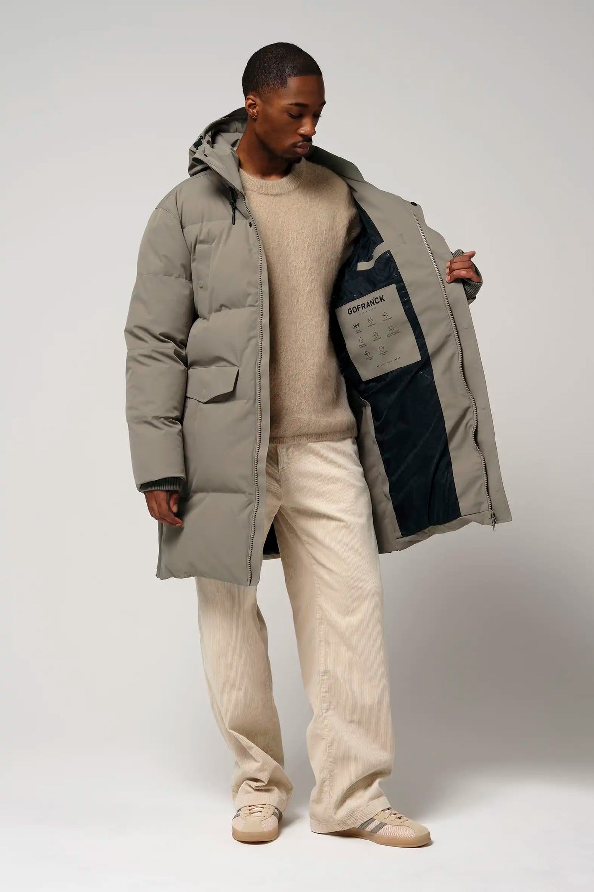 Model wearing Climate Timber Wolf Grey Coat with opened zipper, showcasing interior pockets and design elements.