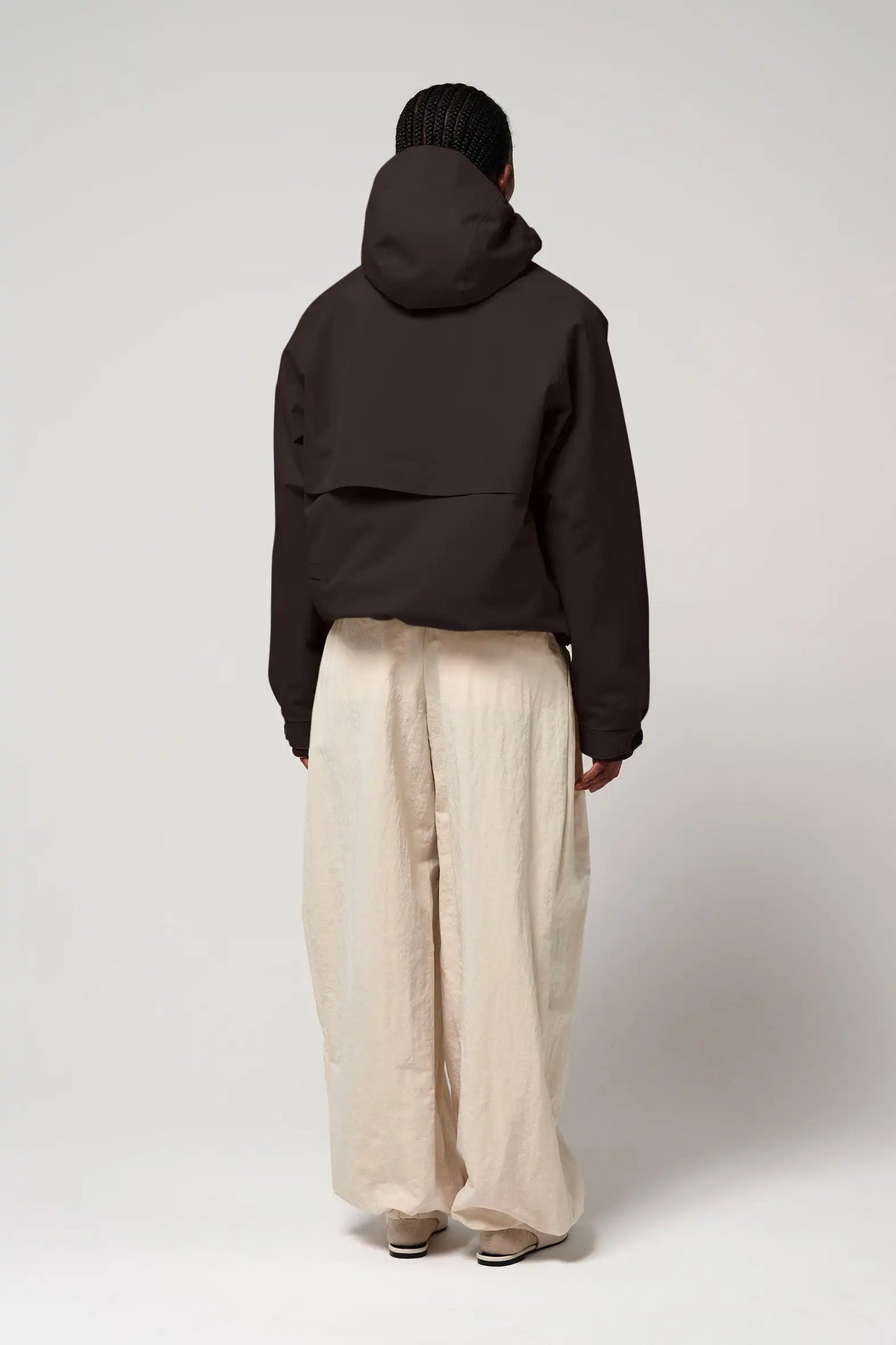 Guthrie Black Coffee Coat displayed from the back, highlighting its adjustable hood and sleek design.