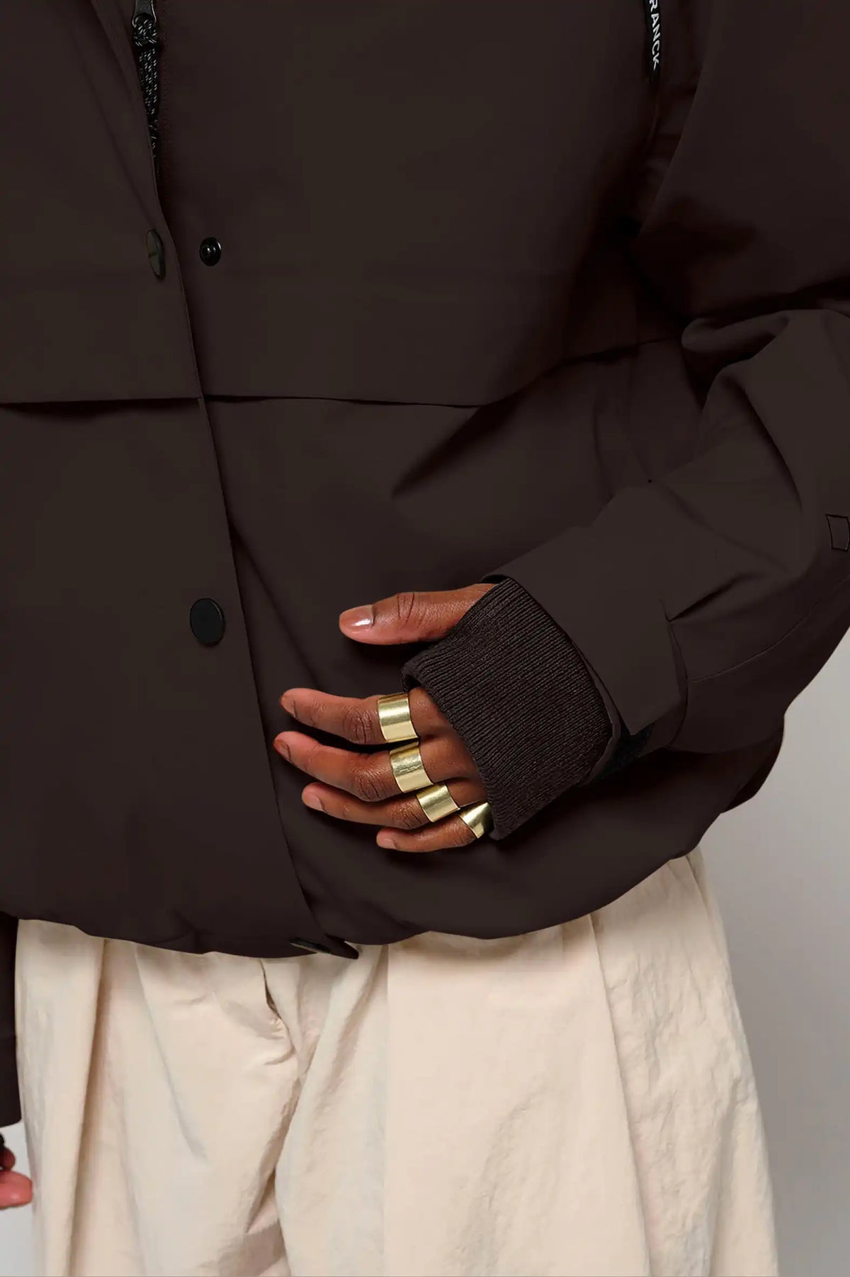 Guthrie Black Coffee Coat featuring waterproof design and stylish cuffs with thumb holes.
