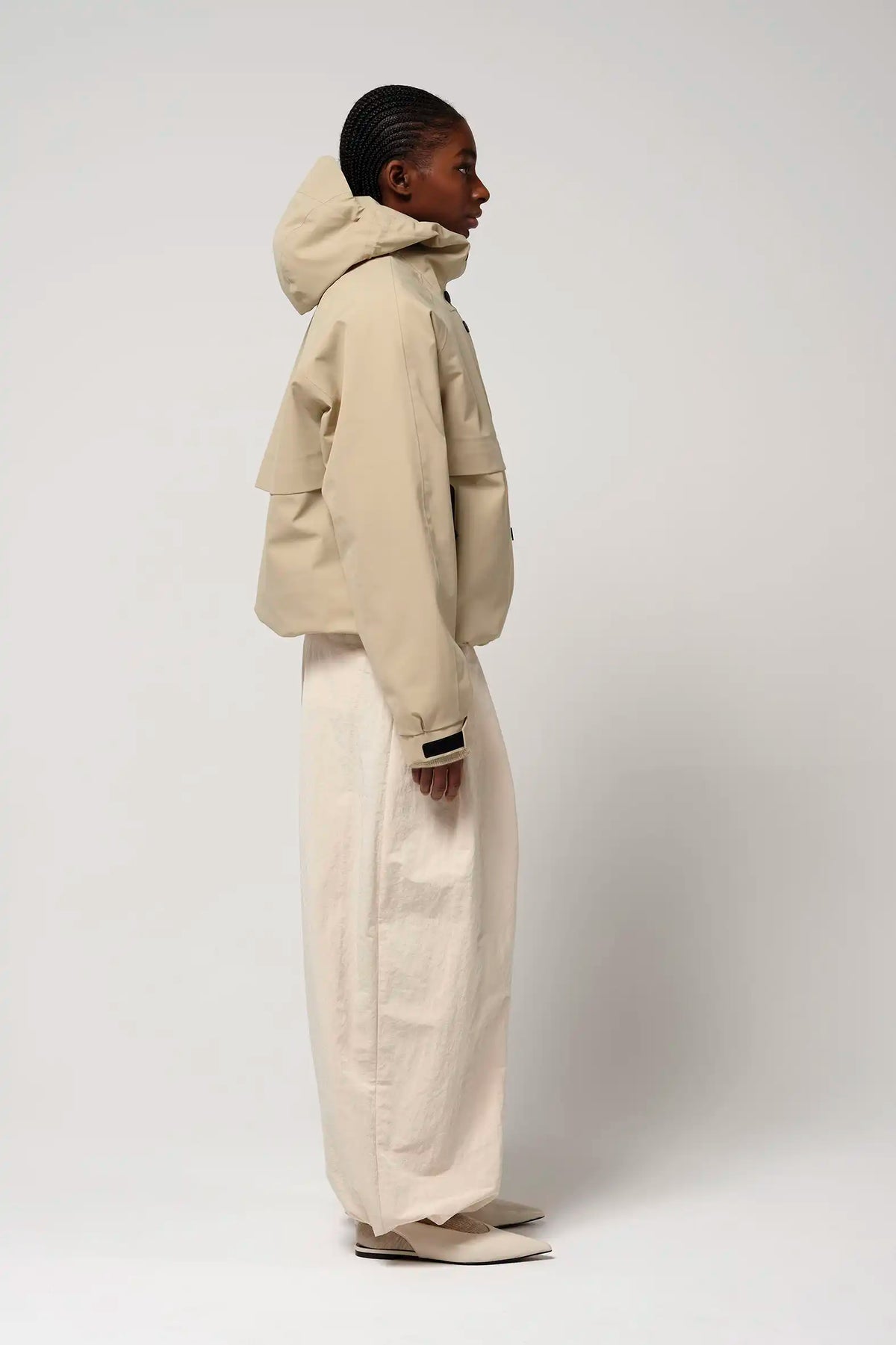 Guthrie Fields of Rye Beige Coat shown on a model, featuring an adjustable hood and two outer pockets.