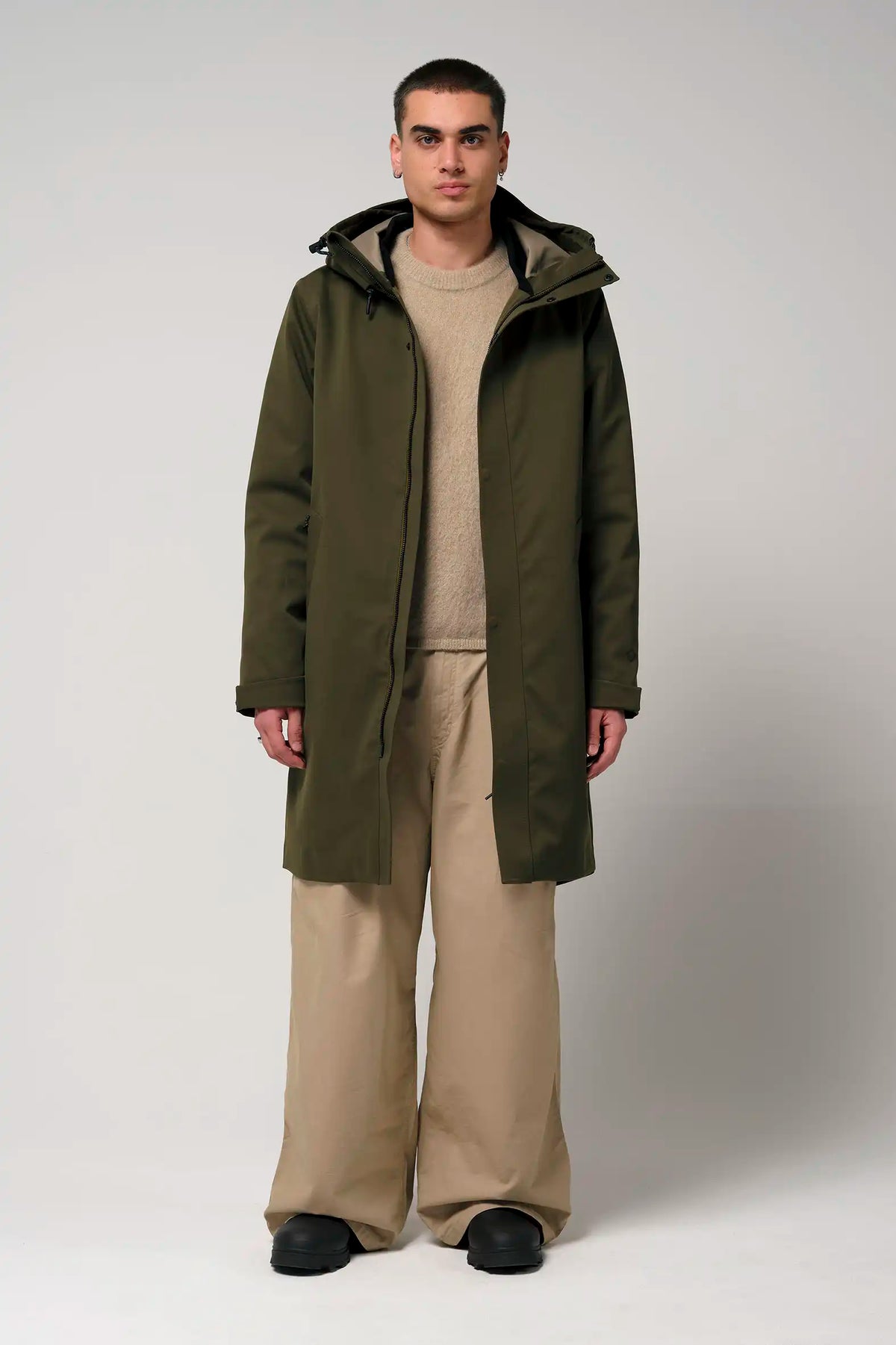 Raiden Dark Olive Green Parka worn by a model, showcasing its waterproof, breathable design and adjustable hood.