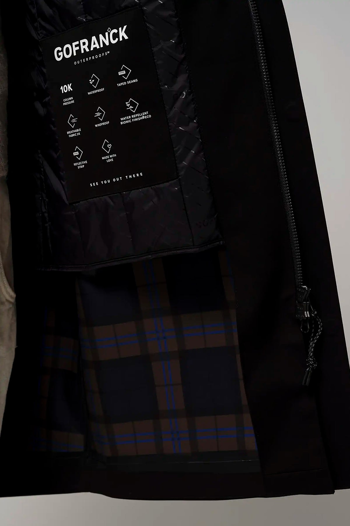 Interior view of Raiden Deep Black Parka showing waterproof insulation and plaid lining.