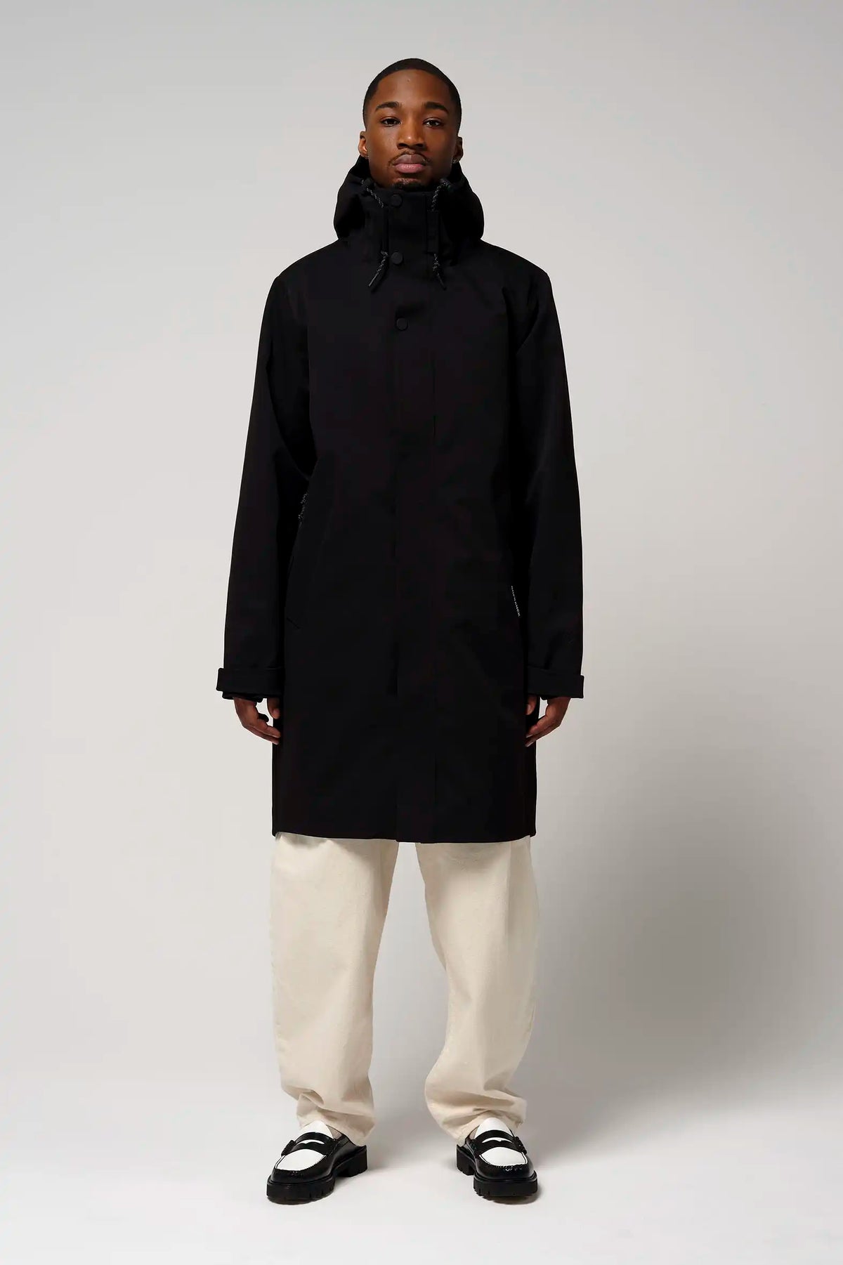 Model wearing Raiden Deep Black Parka, featuring breathable, waterproof design, with adjustable hood and two-way zipper.
