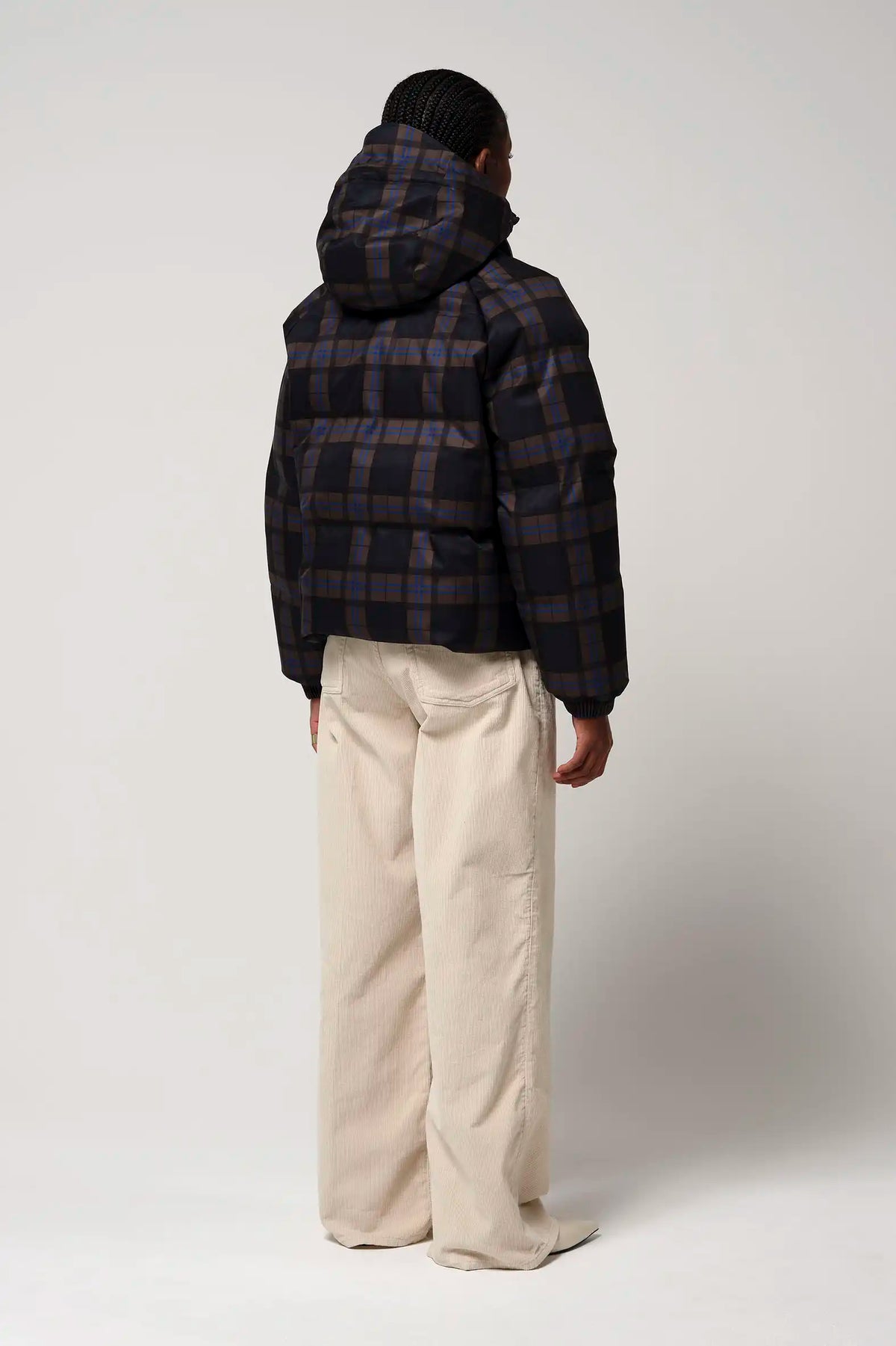 Person wearing Talon Blue Tartan Check Coat, showcasing back view and adjustable hood with plaid design.