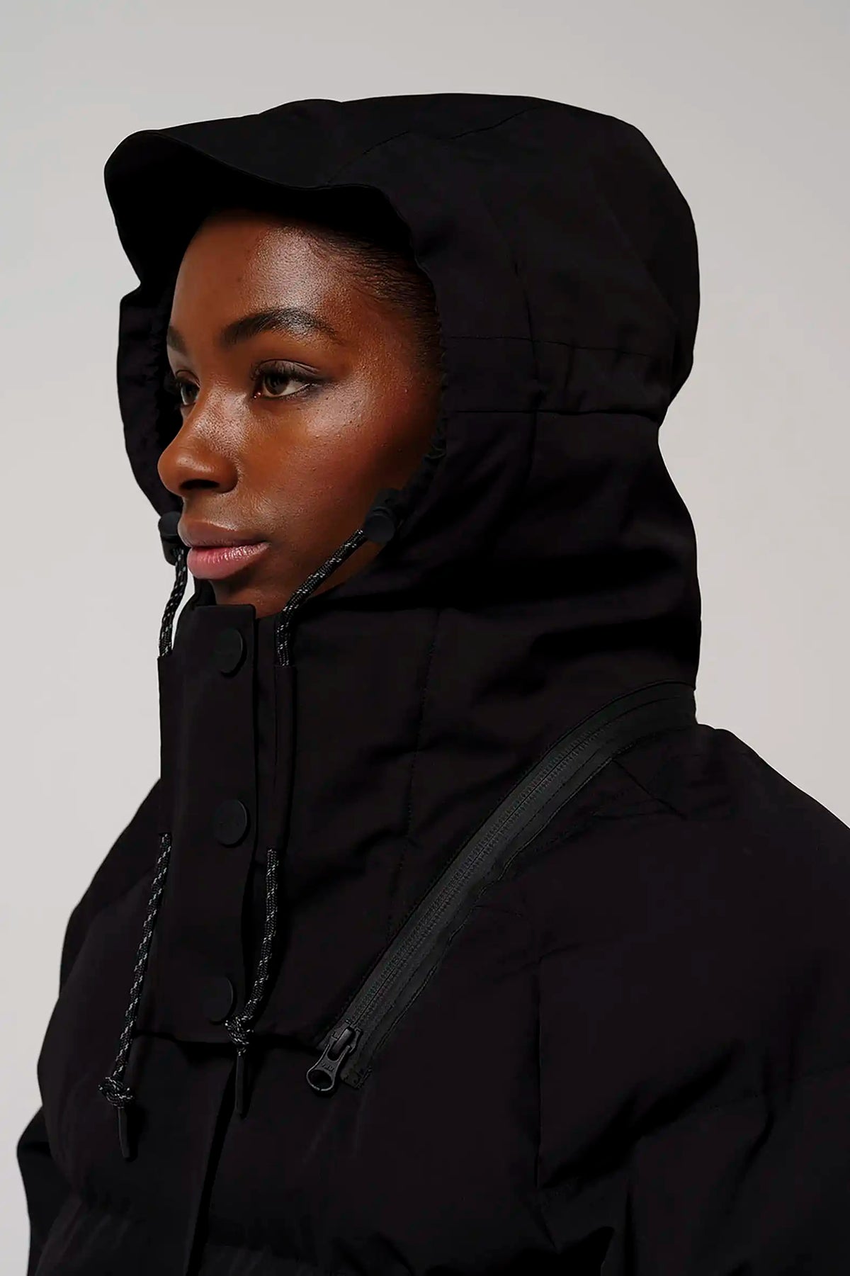 Model wearing Talon Deep Black Coat with adjustable hood and waterproof features.