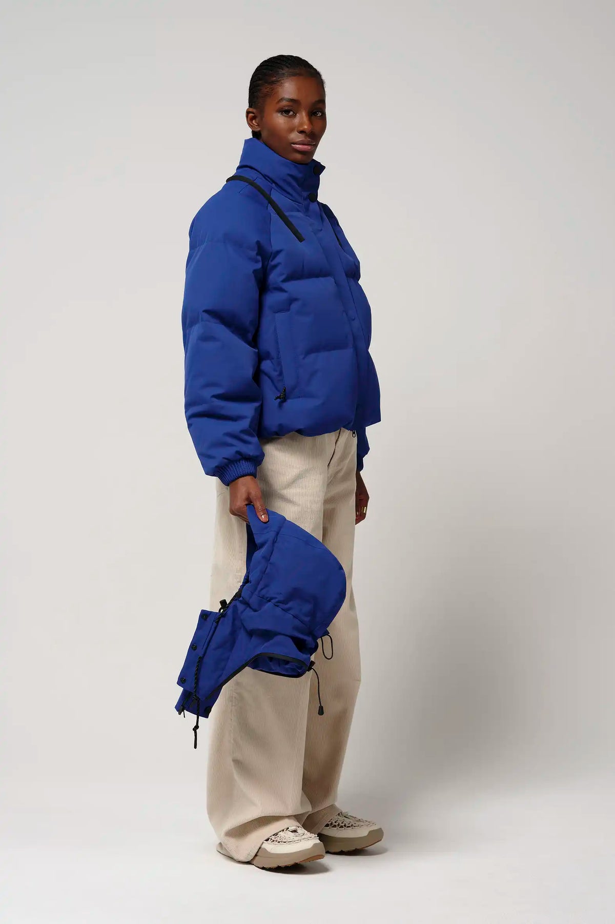 Model showcasing Talon Sodalite Blue Coat with removable hood and dual pockets, perfect for rainy weather.