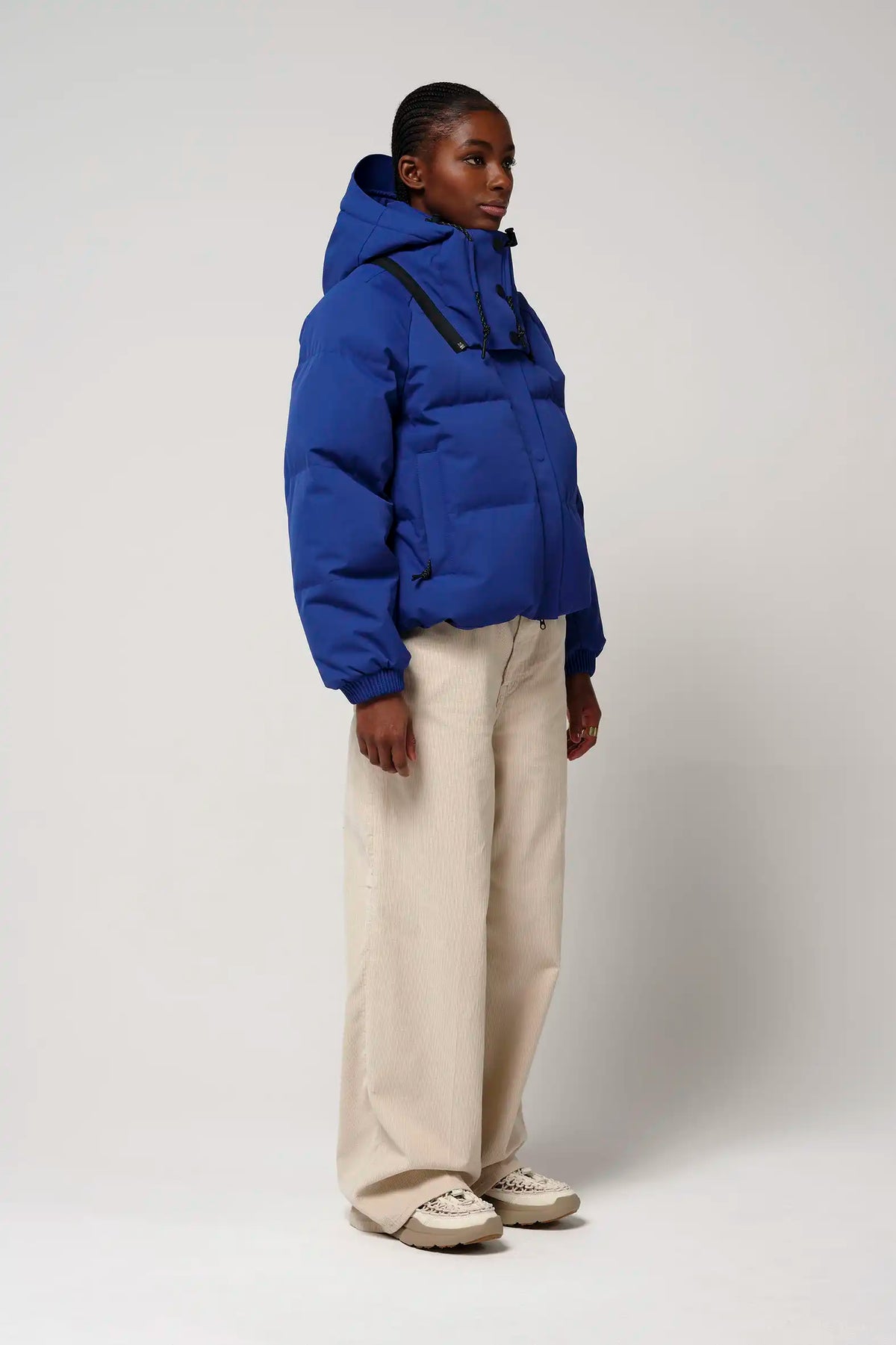 Model wearing the Talon Sodalite Blue Coat, a waterproof and breathable winter jacket, with a removable hood.