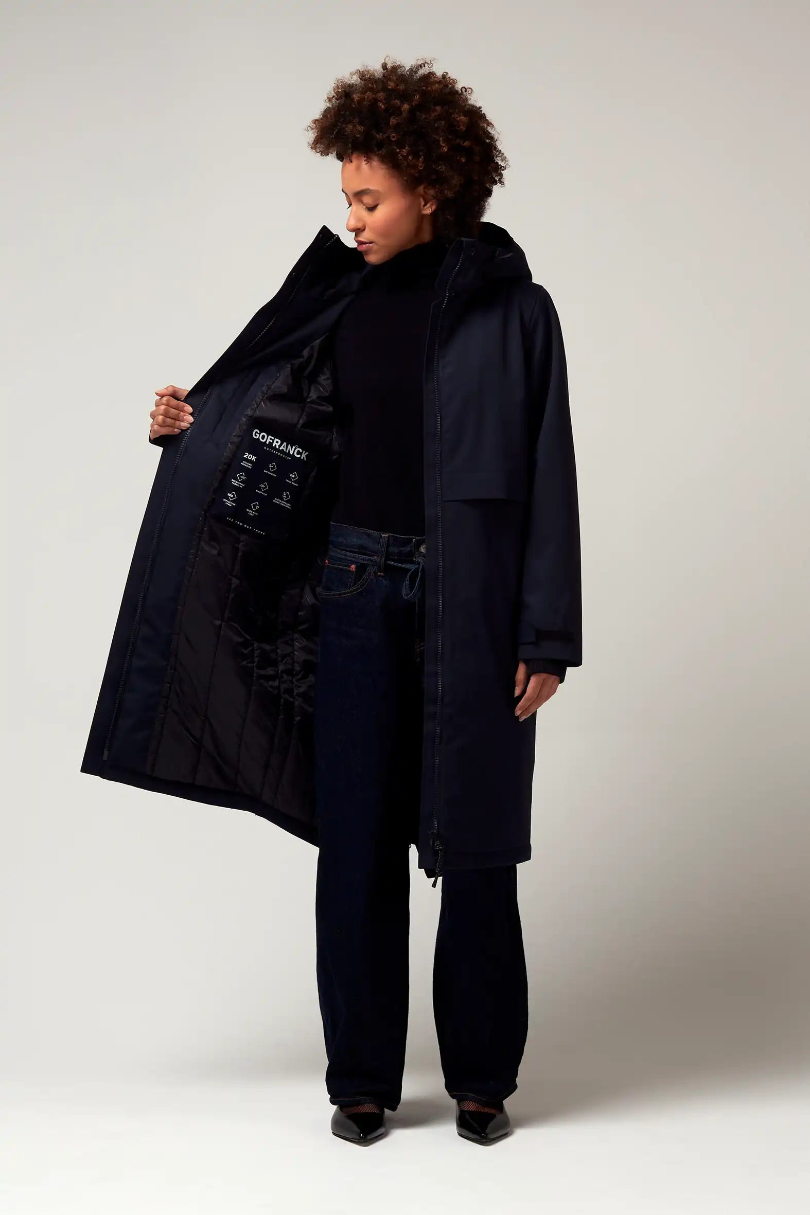 Woman wearing Nebula Sky Captain Blue Coat, showcasing its waterproof design and adjustable hood.