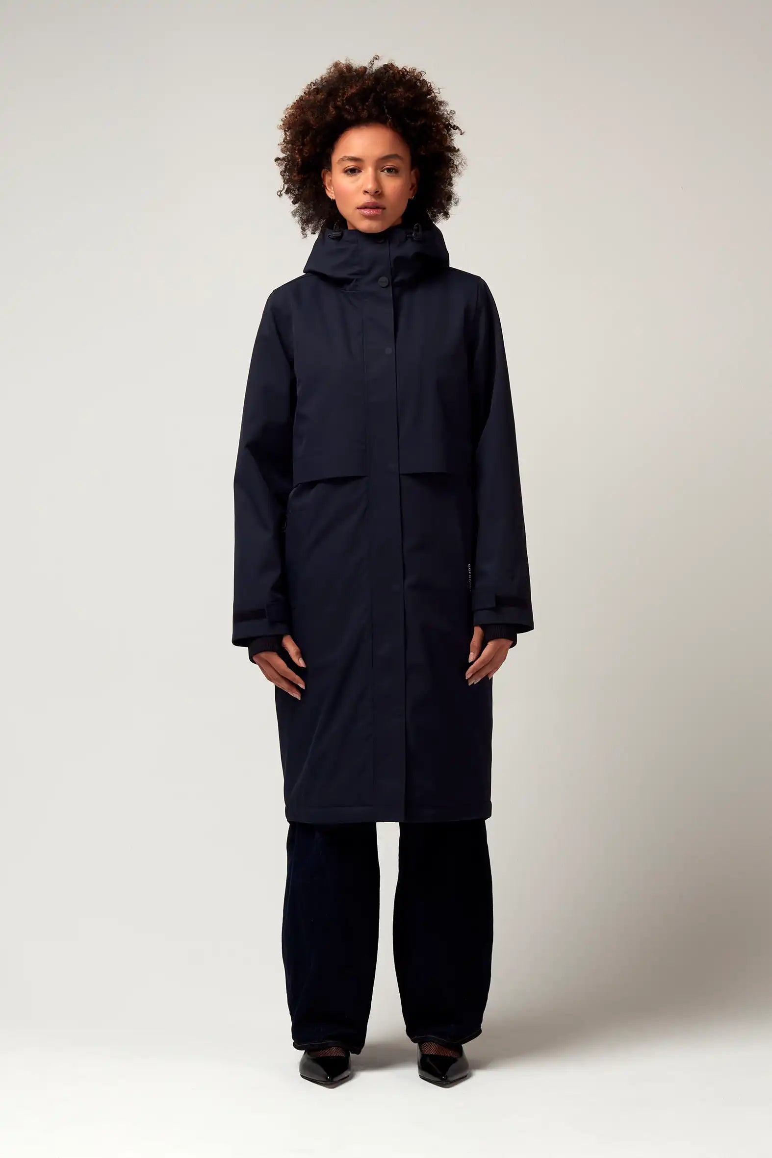 Model wearing Nebula Sky Captain Blue Coat, showcasing its waterproof design and adjustable hood.