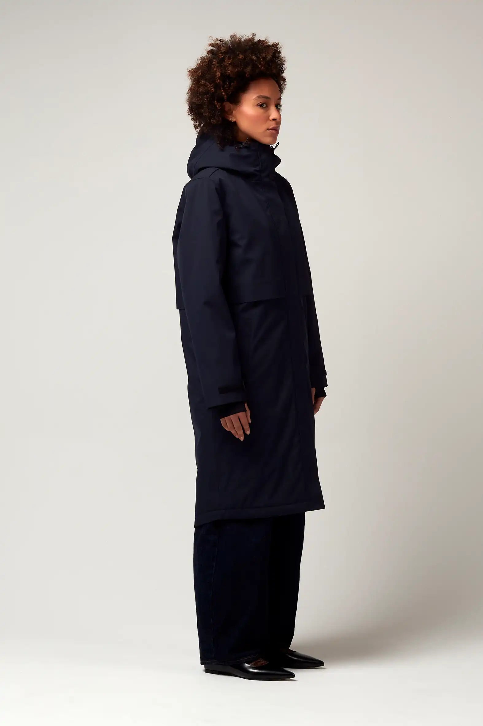 Model wearing Nebula Sky Captain Blue Coat, a waterproof and breathable coat with adjustable hood and concealed magnetic closure.