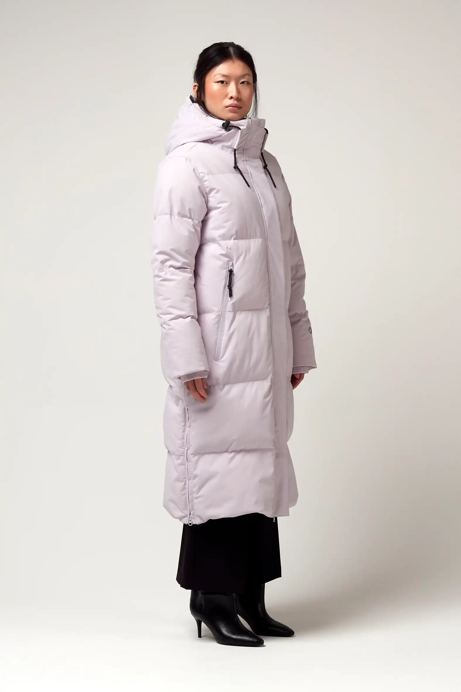 Model wearing the Tsunami Lilac Orchid Coat, featuring a lightweight, waterproof, and windproof design.