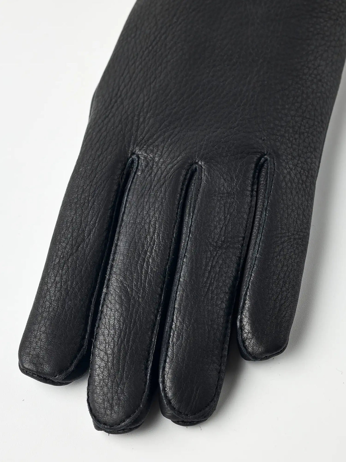 Close-up of Tiril Black Gloves by Hestra, made of supple deerskin leather with a beautiful grain texture.