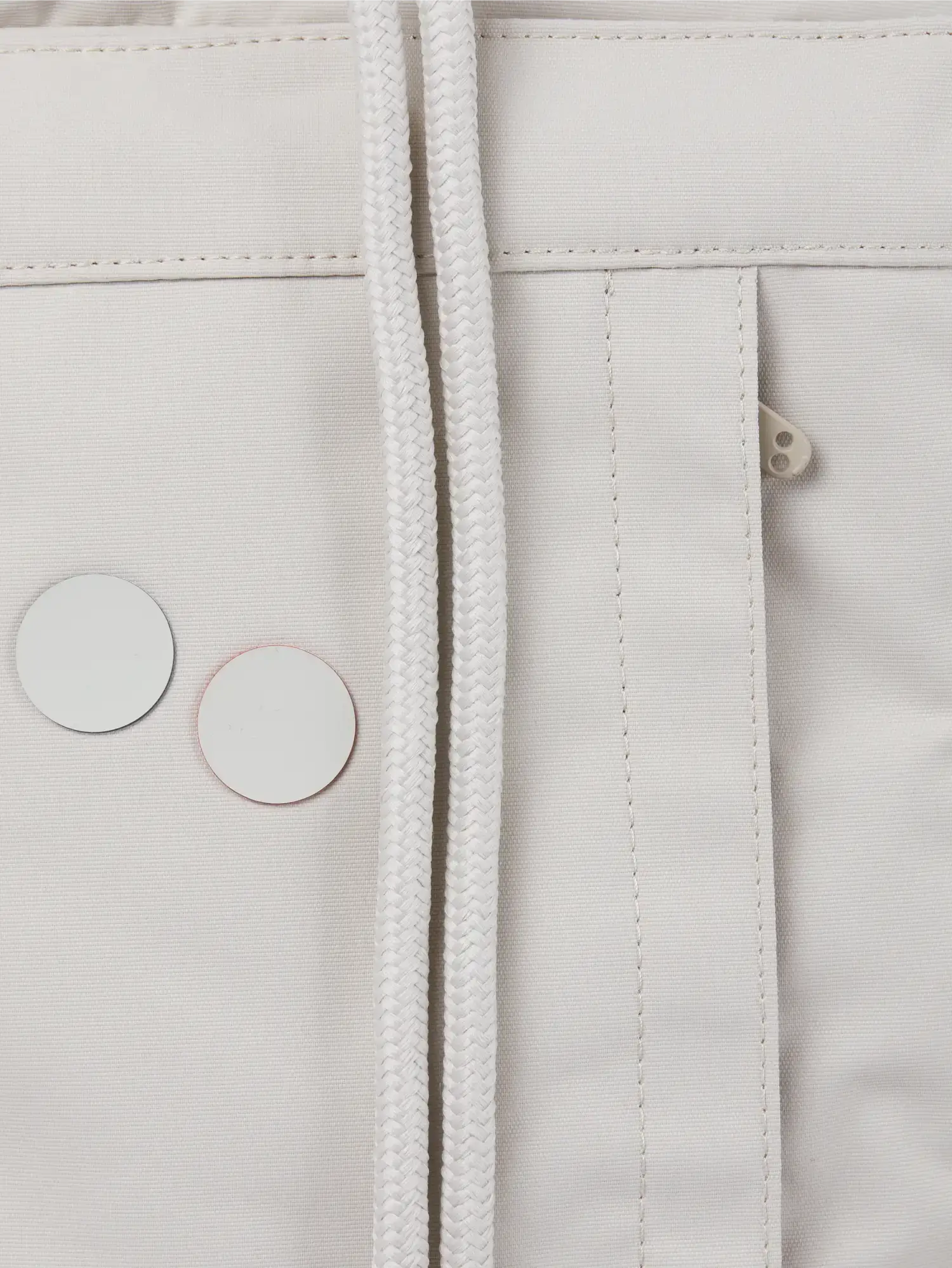 Close-up of the Blok Medium Cliff Beige Backpack showing fabric details and drawstrings.