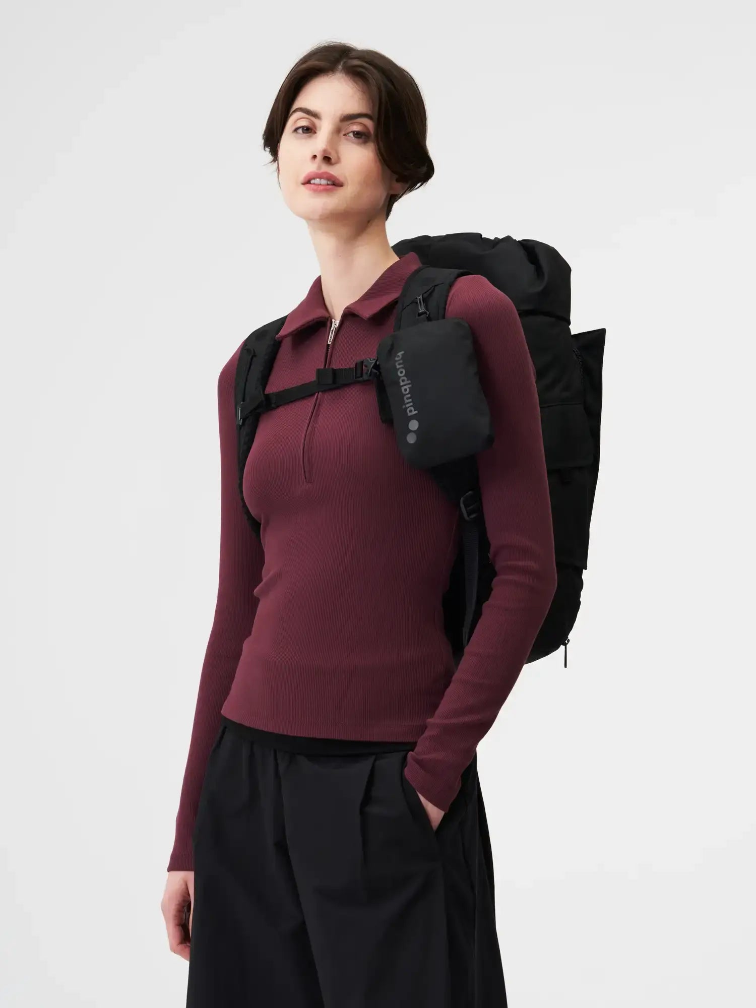 Woman modeling the Blok Medium Construct Black Backpack with padded straps and a stylish design.