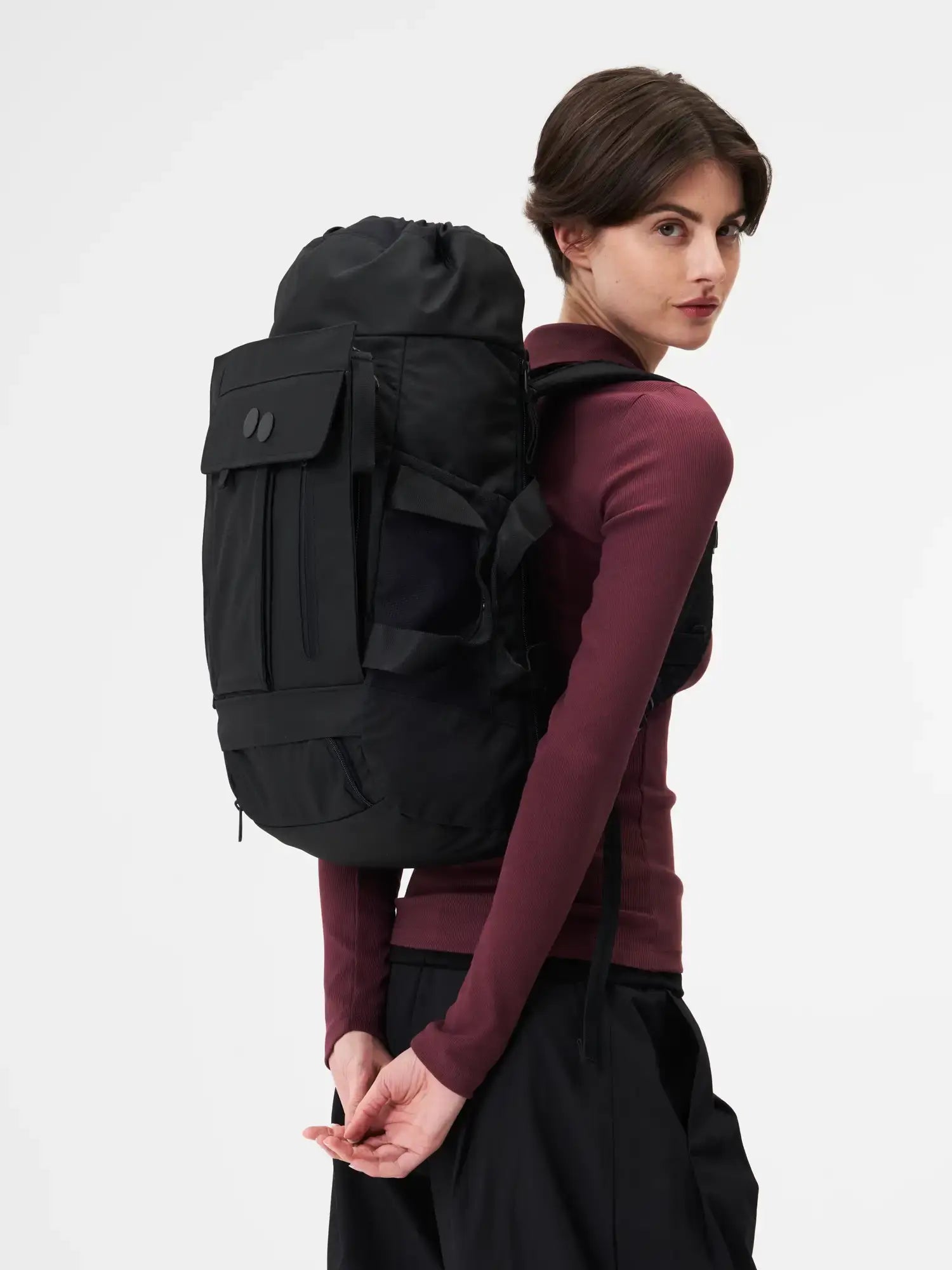 Blok Medium Construct Black Backpack worn by a model, showcasing its sleek design and features.