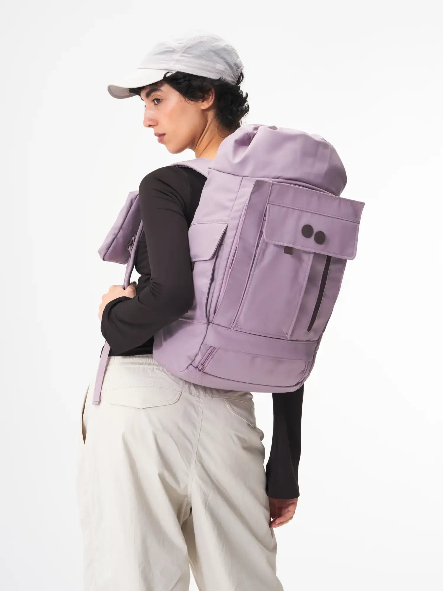 Blok Medium Construct Lilac Backpack worn by a model with a grey cap, showcasing its stylish design and functionality.