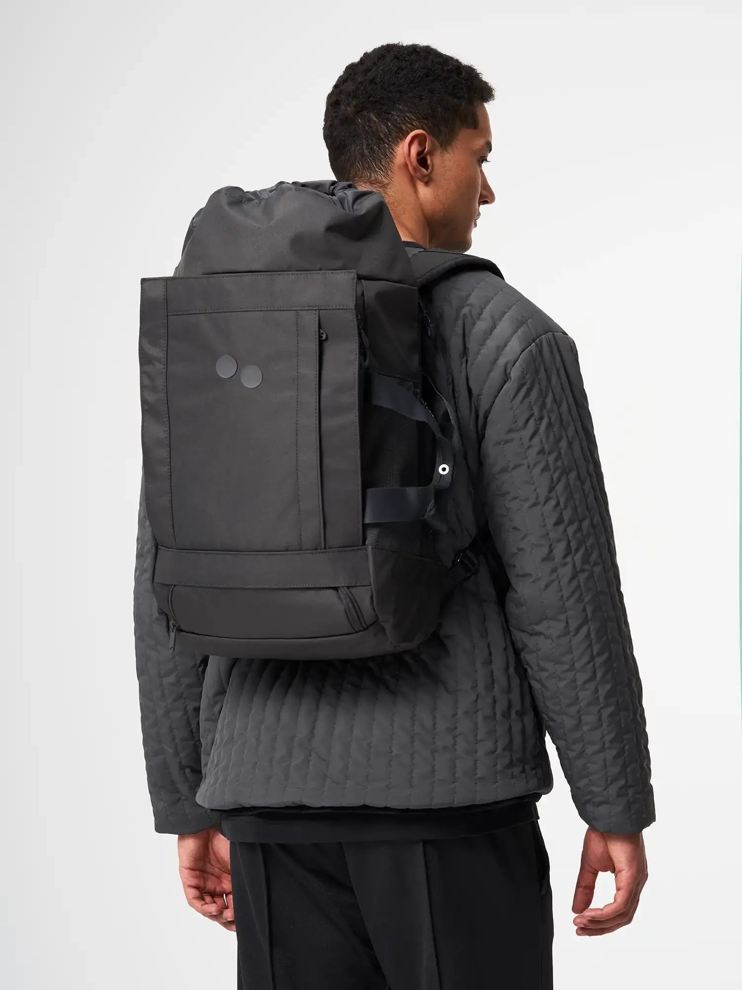 Blok Medium Deep Anthra Backpack worn by a model, showcasing its sleek design and functionality.