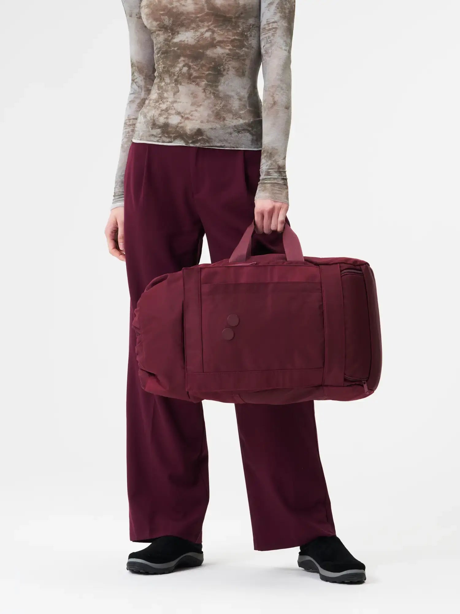 Blok Medium Glazed Red Backpack displayed by a person in maroon outfit, showcasing its stylish design for outdoor use.