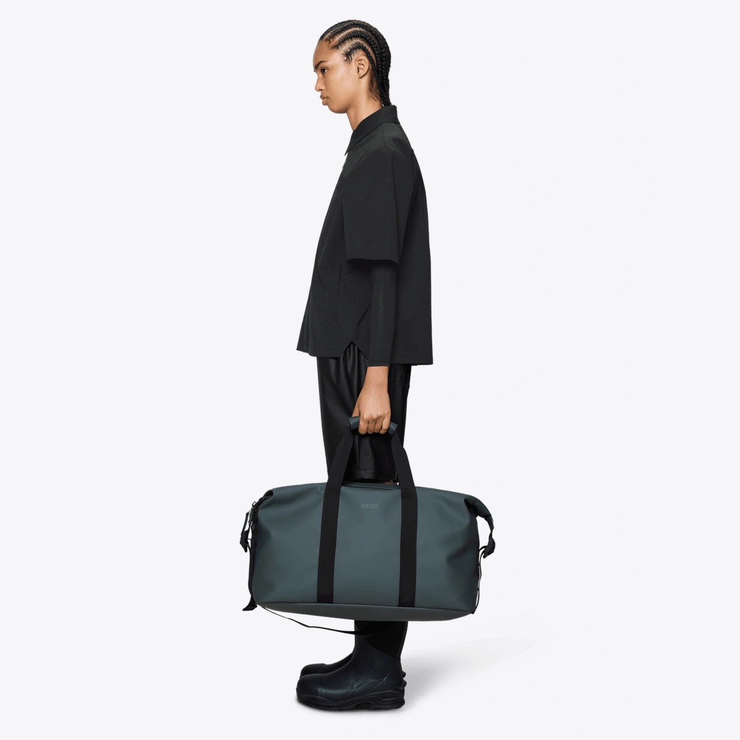 Weekend Bag Dark Grey being held by a model, showcasing its waterproof design and spacious compartments.