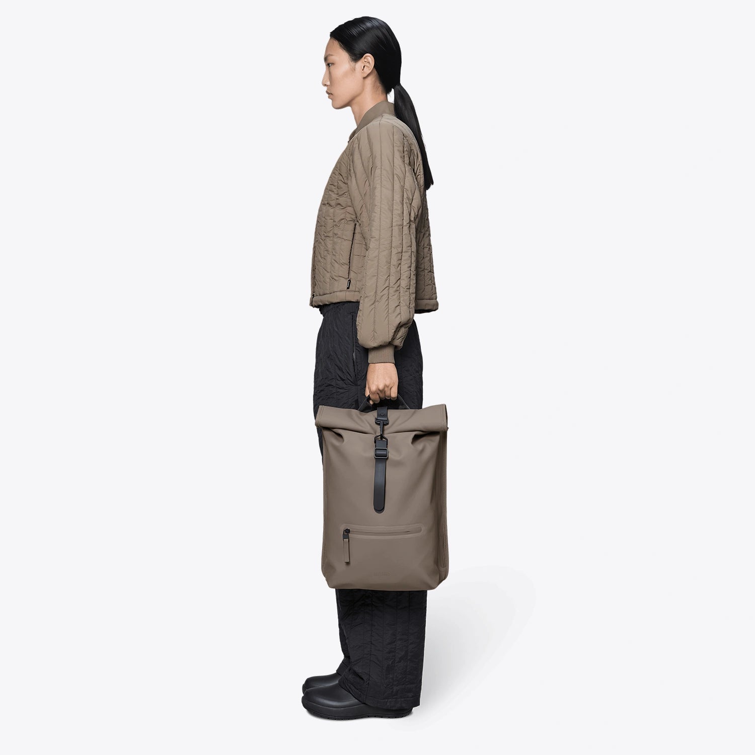 Rolltop Rucksack Cinder Backpack shown in a side view, featuring a roll-top closure and stylish design.