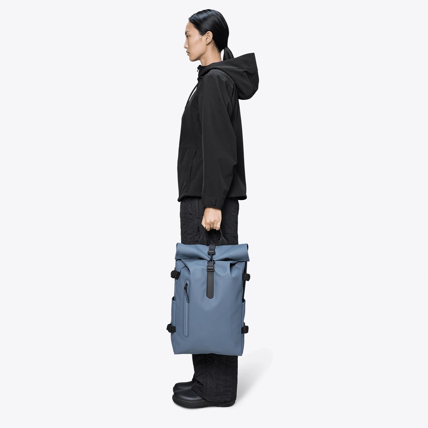 Rolltop Rucksack Large Blue Dusk Backpack displayed by a model standing in profile.