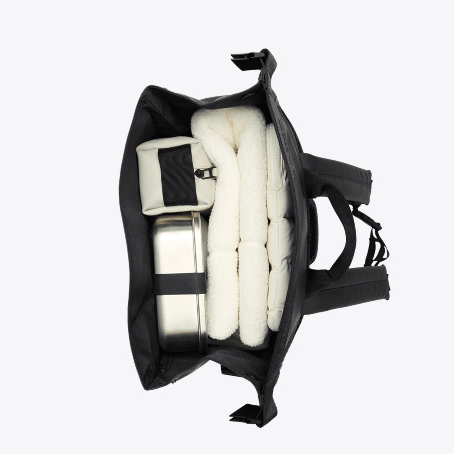 Interior view of the Trail Mountaineer Rolltop Beige Backpack with packed items, showcasing its spacious design and organization.