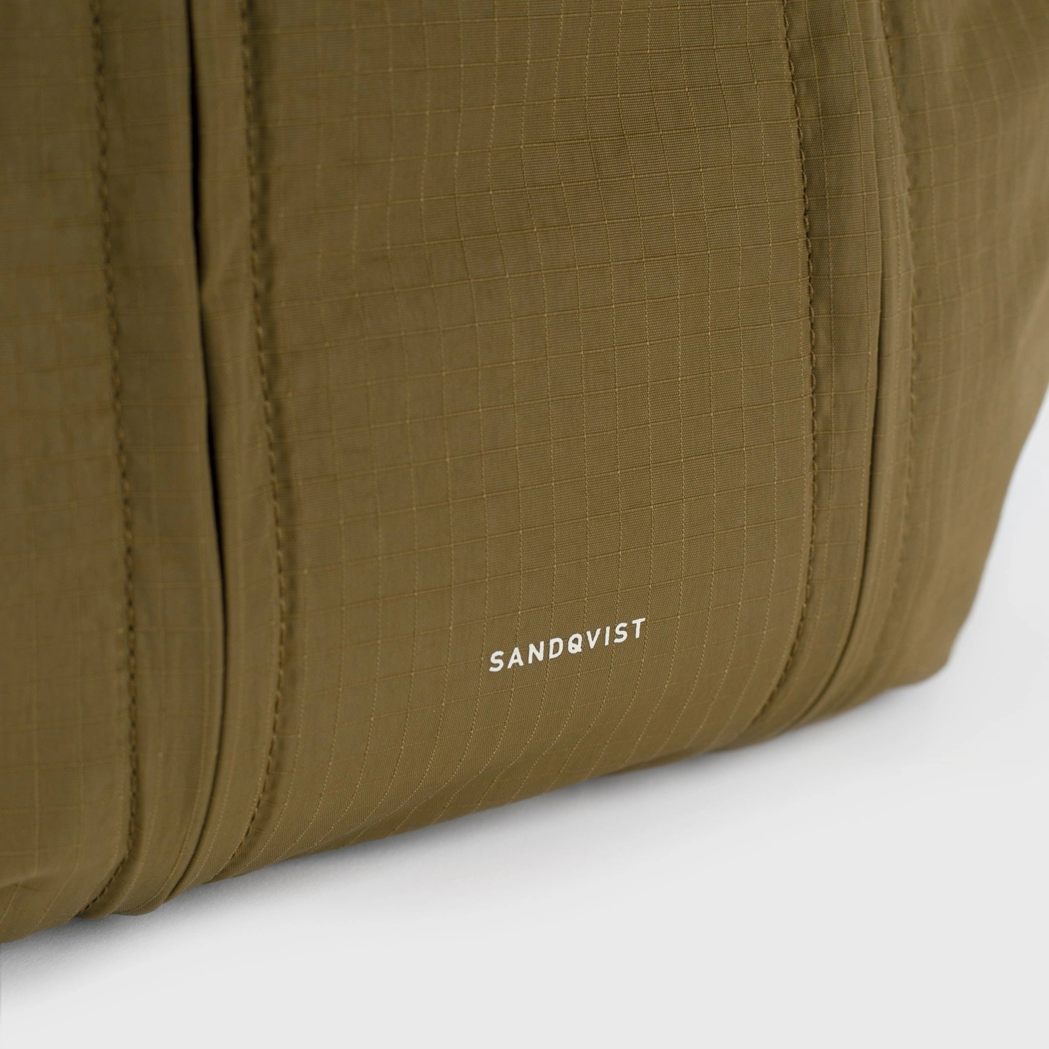 Grid Crossbody Bag Olive Shoulder Bag features durable ripstop fabric and sandqvist branding close-up.