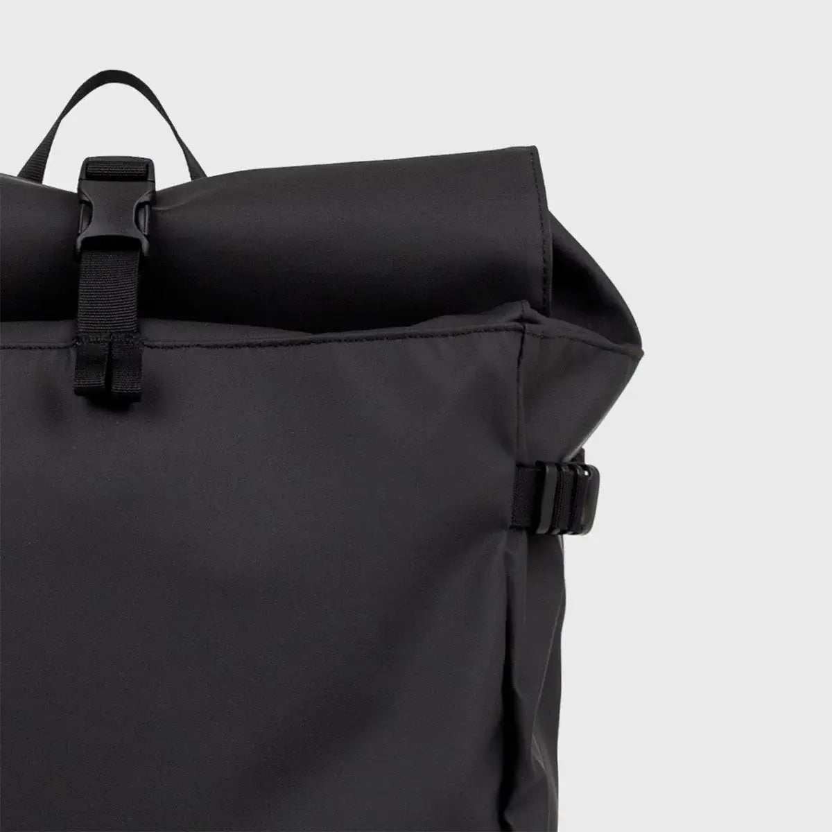 Stream Slim Rolltop L Black Backpack close-up view showing waterproof material and buckle detail.