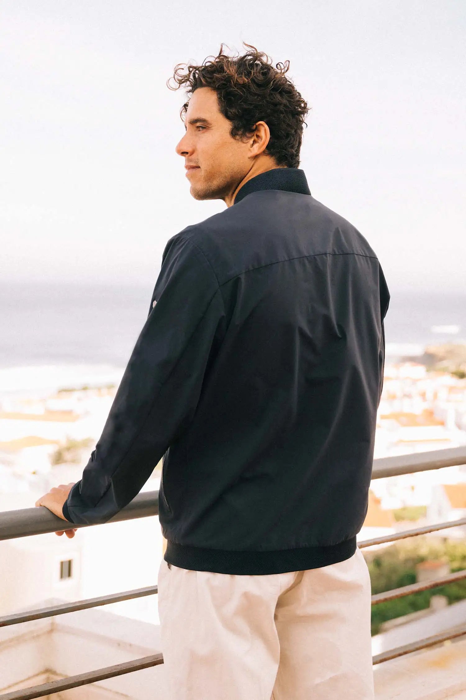 Man wearing a Campo II Navy Jacket, showcasing lightweight design and stylish fit against scenic backdrop.