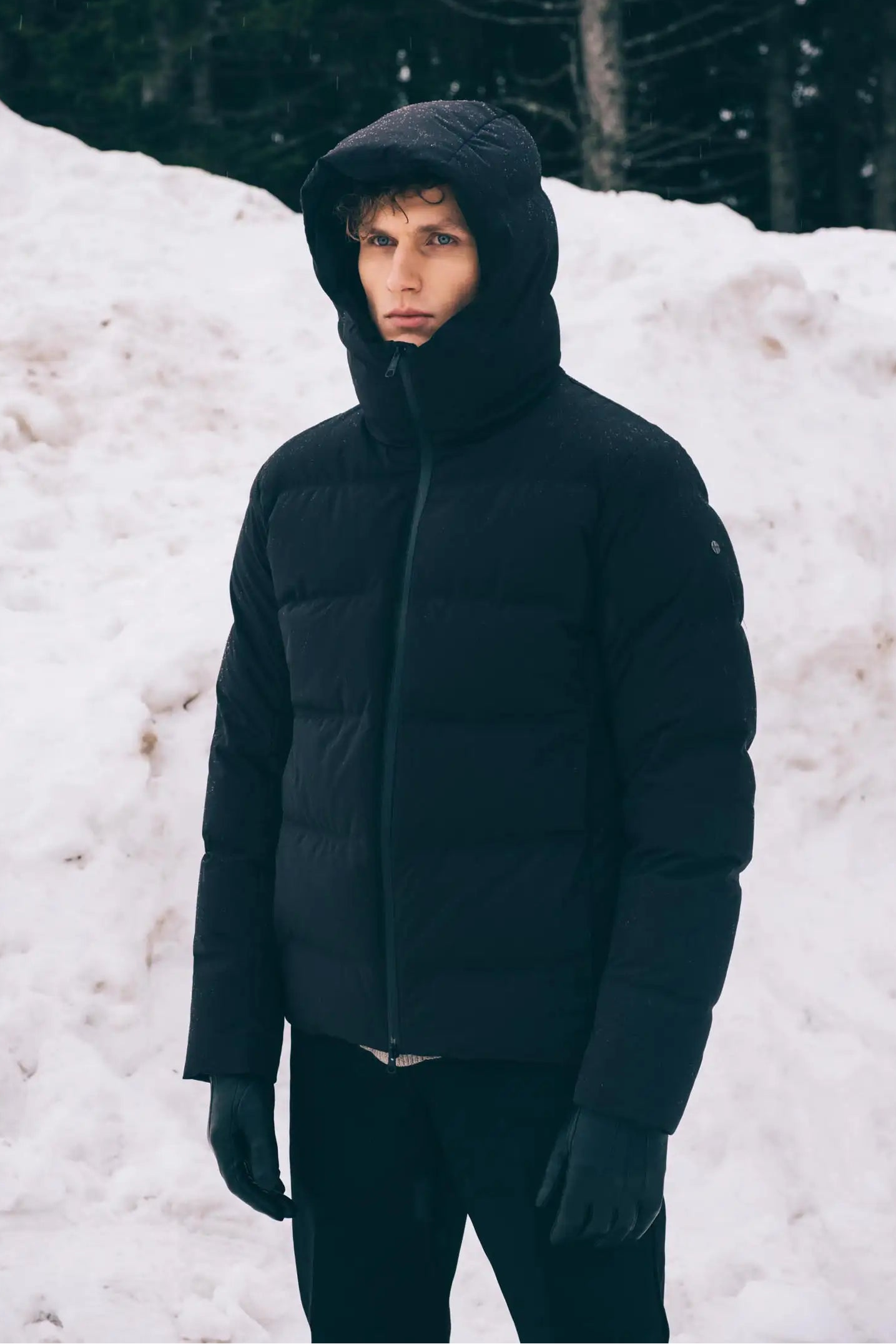 Torrent II Onyx Coat worn by a model standing in snow, showcasing warmth and waterproof features.