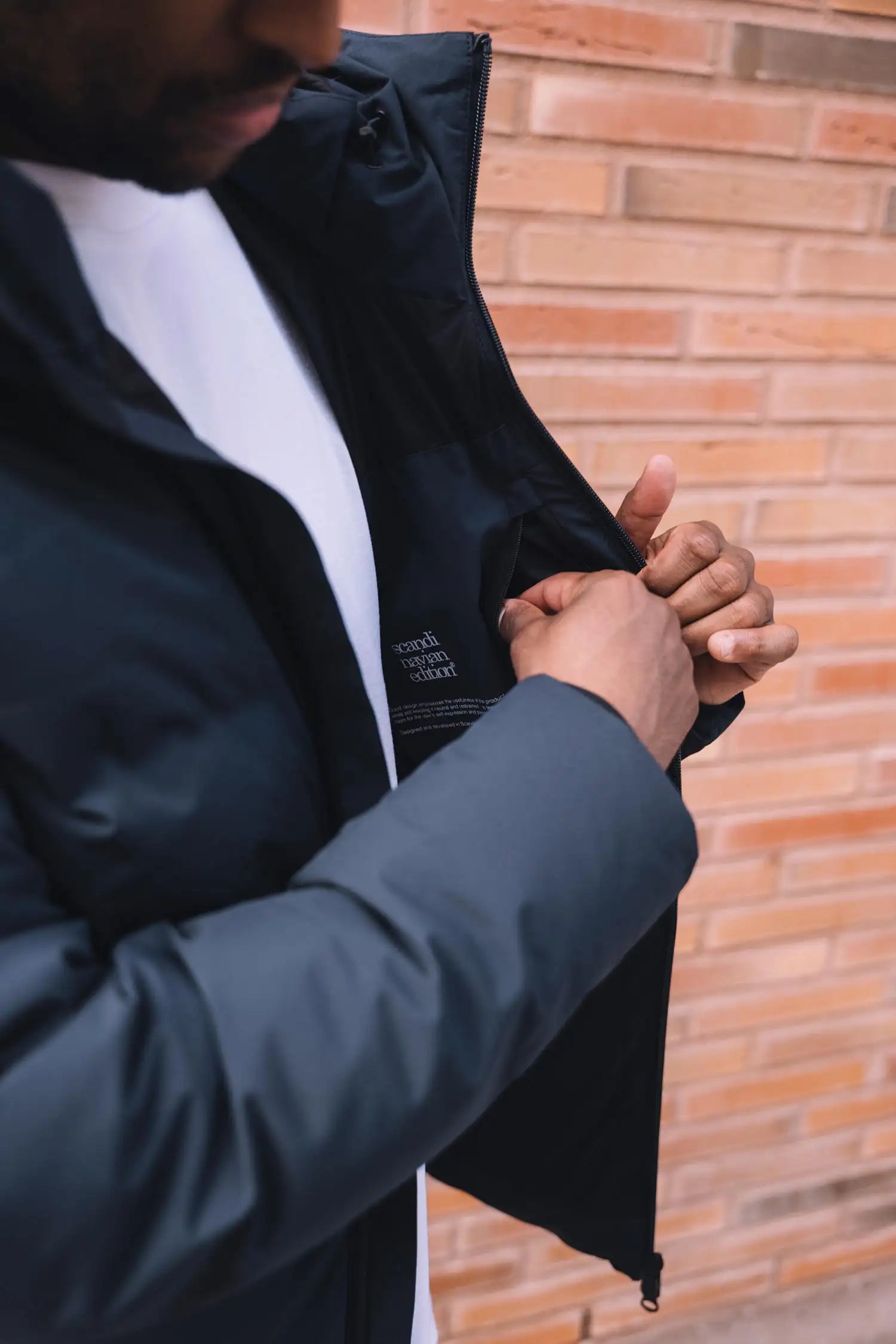 Man adjusting the Torrent II Onyx Coat showcasing its waterproof and breathable features.