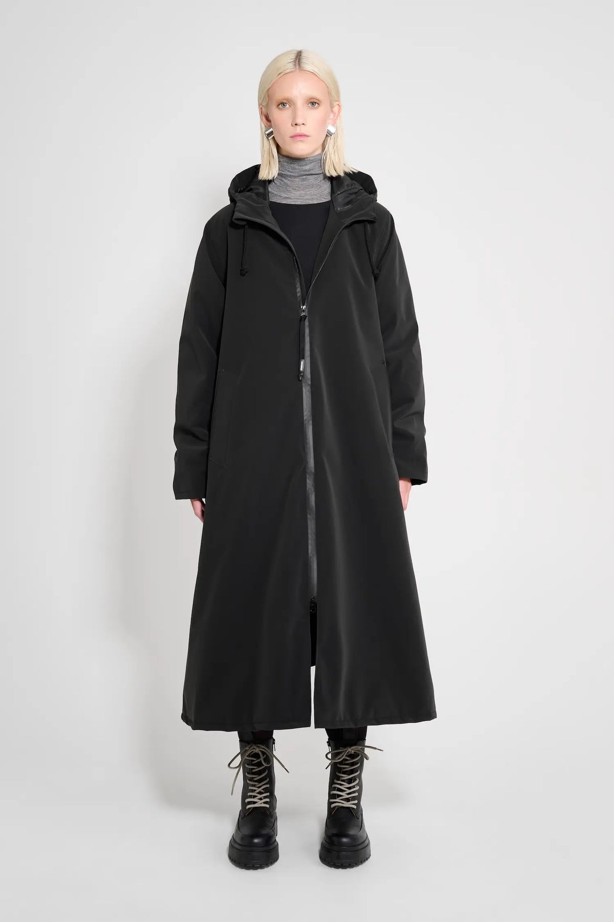 Mosebacke Long Matte Black Winter Coat on model, showcasing adjustable hood and sleek design.