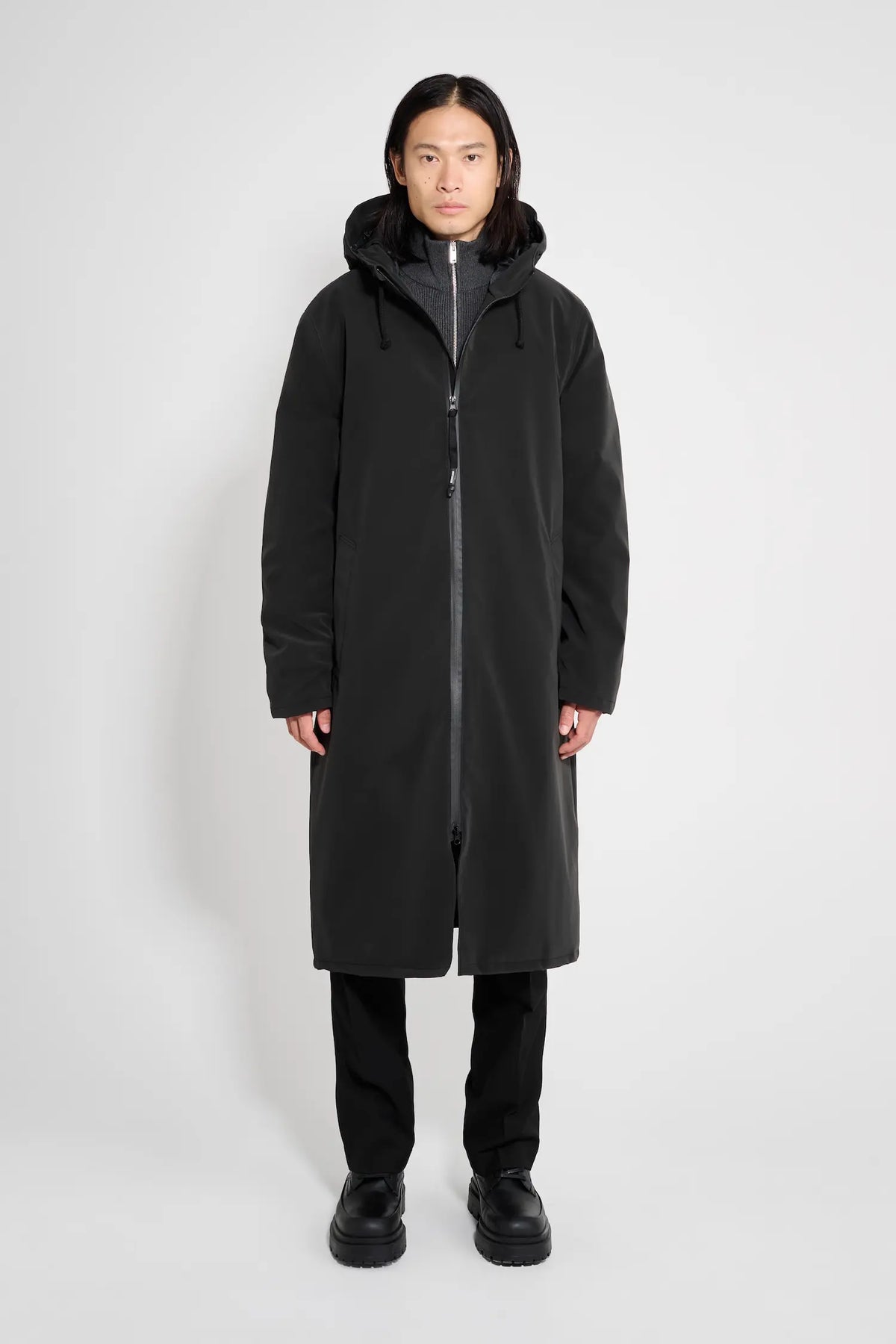 Stockholm Long Matte Black Winter Coat worn by a model, showcasing its oversized fit and adjustable hood.