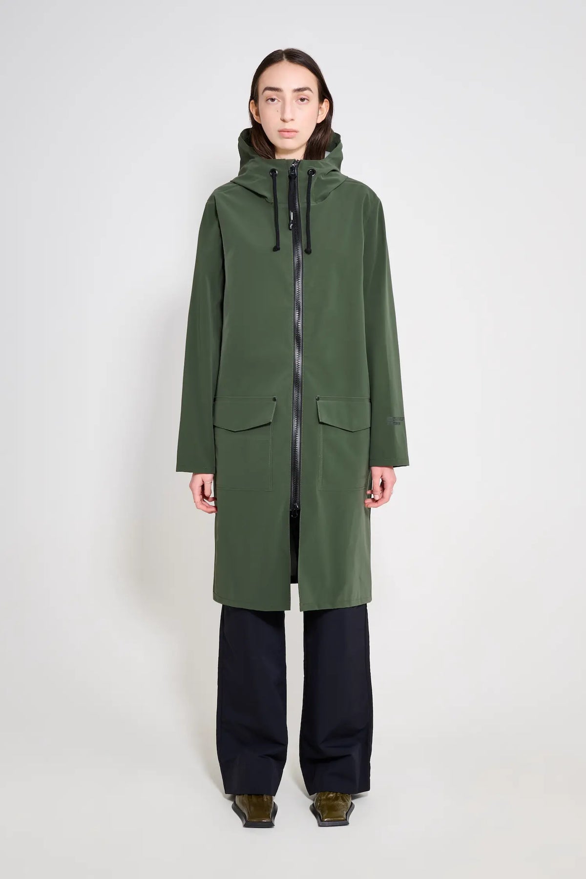 Stockholm Long Patch Matte Green Raincoat on model, showcasing waterproof design and oversized fit for unisex wear.